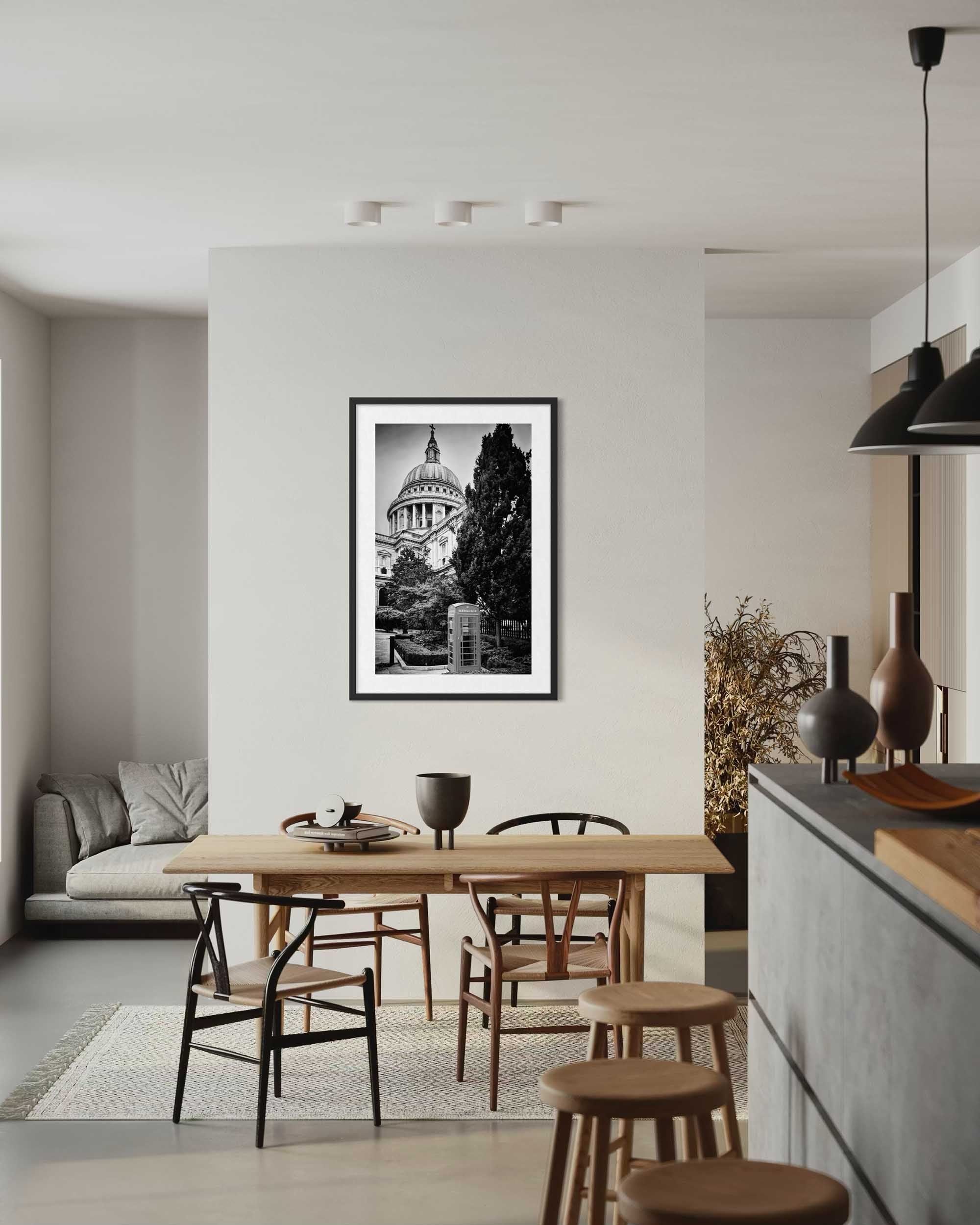 Modern kitchen with wooden dining table and chairs, framed black and white artwork on wall.