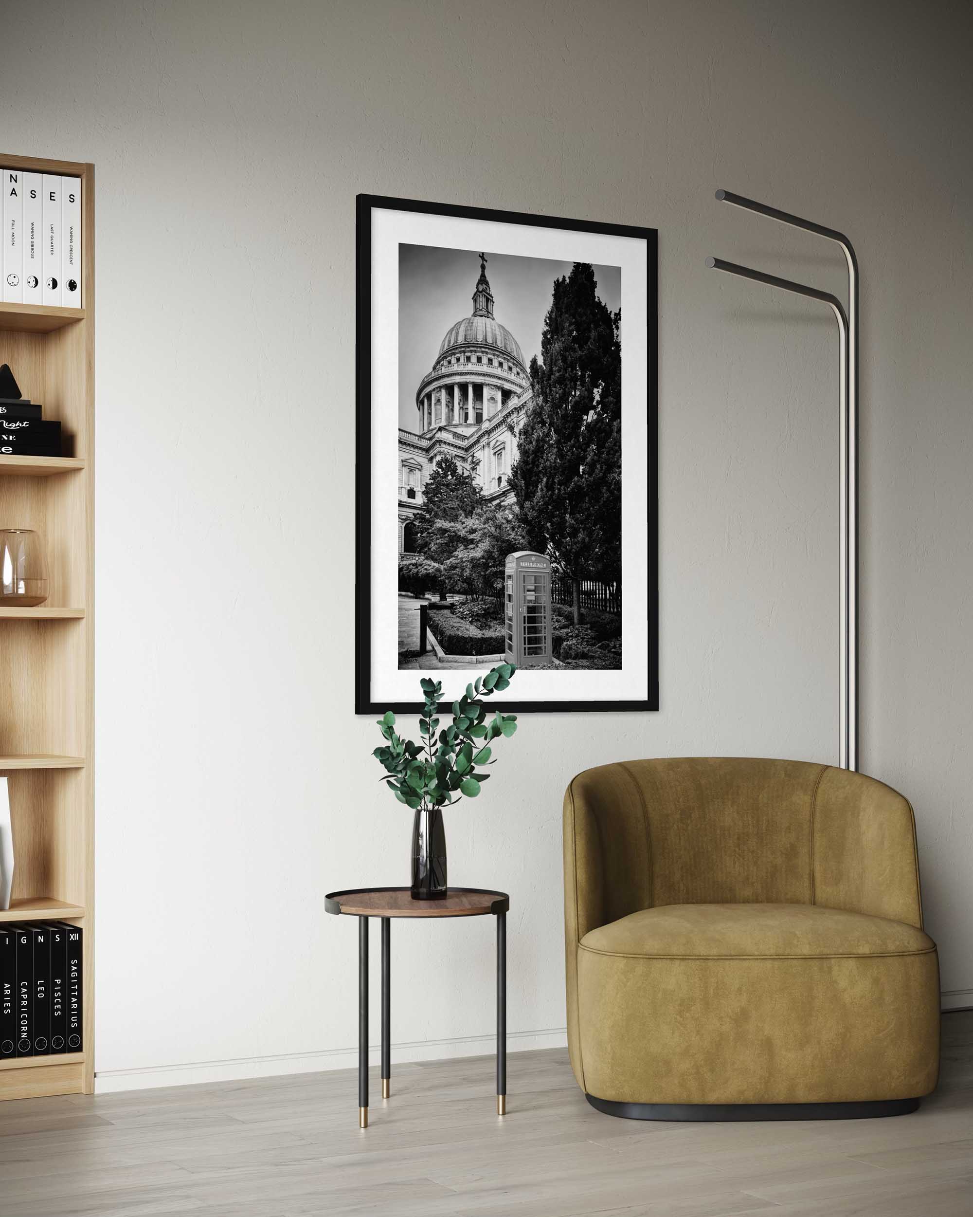 Modern interior with a framed black and white photo, bookshelf, and armchair.