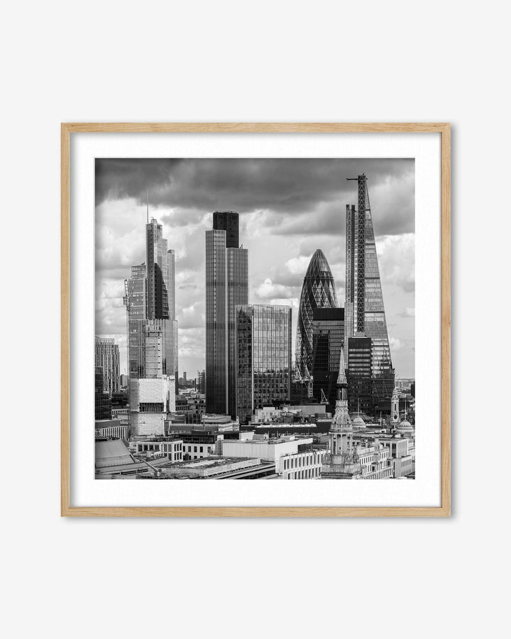 Framed black and white cityscape print of a skyline with modern buildings.
