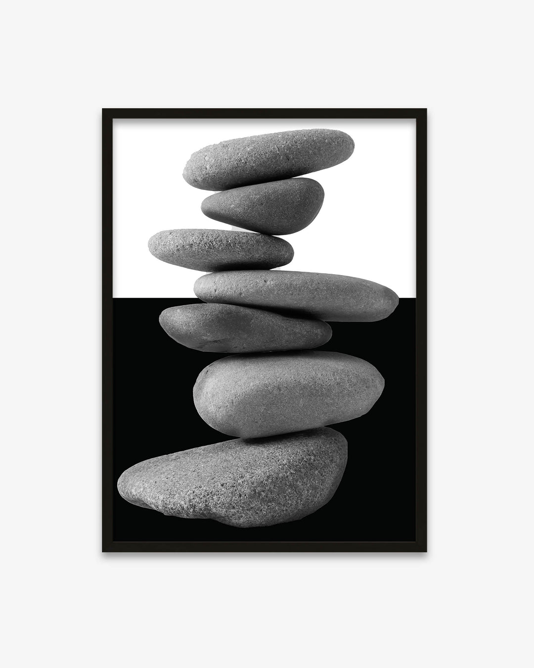 Framed artwork of stacked stones on a white background