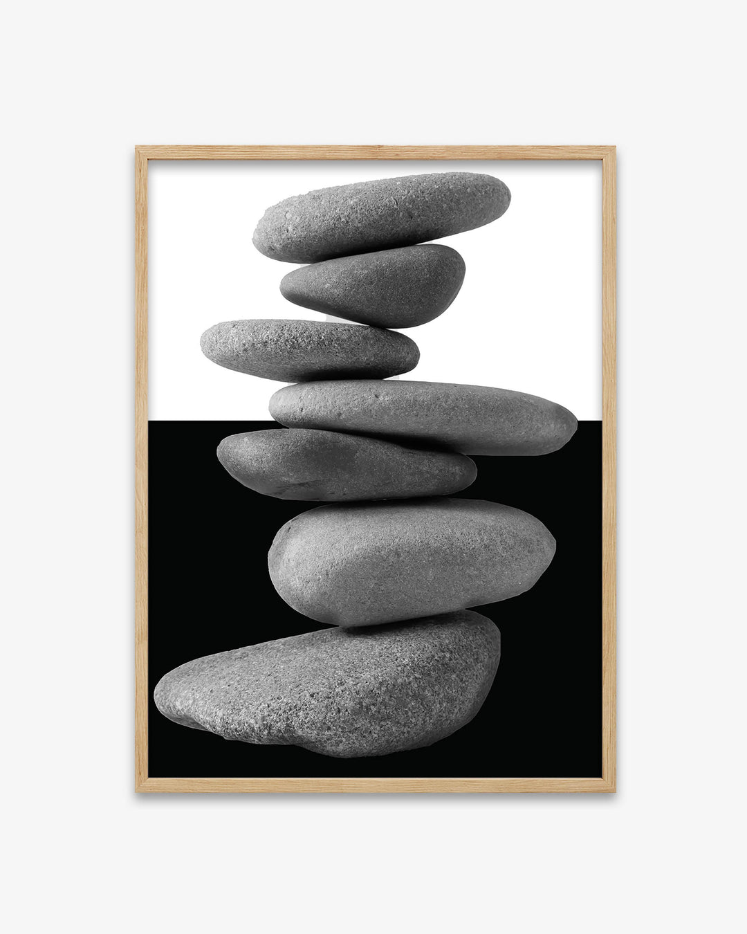 Framed artwork of stacked stones on a black background