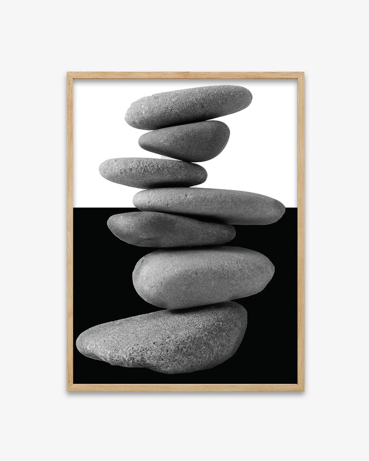 Framed artwork of stacked stones on a black background
