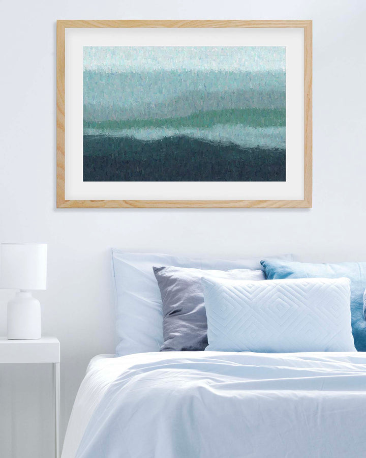 Framed abstract art above a bed with white bedding and blue pillows.