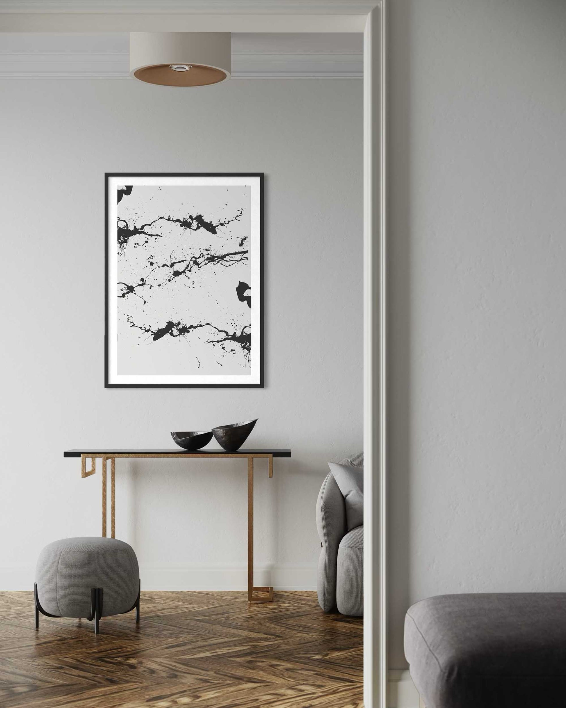 Modern interior with abstract black and white artwork on a wall, wooden console table, and gray chairs.