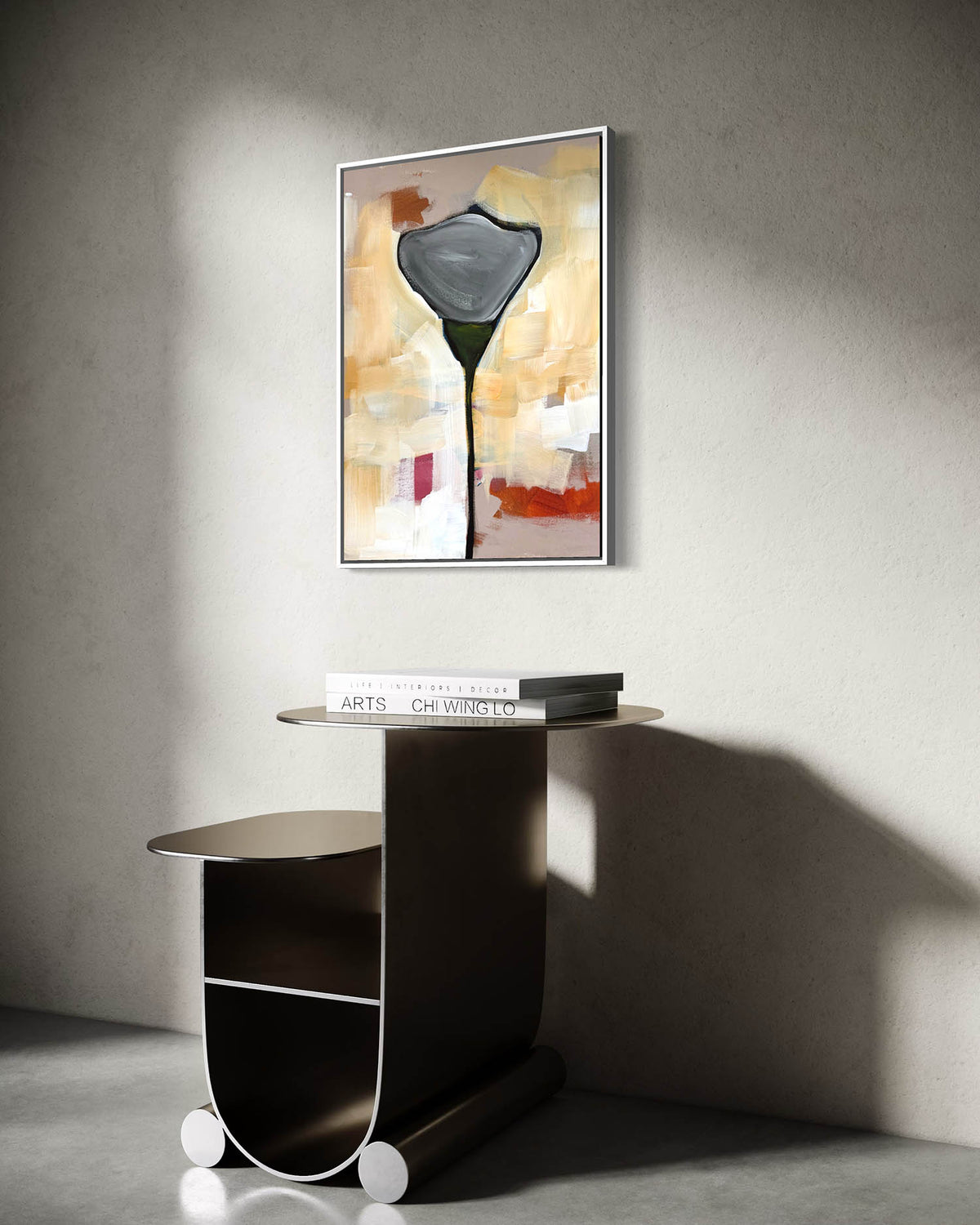 A framed abstract wall art print featuring a dark calla lily on a warm beige and orange background, displayed above a modern dark wood console table against a textured gray wall.
