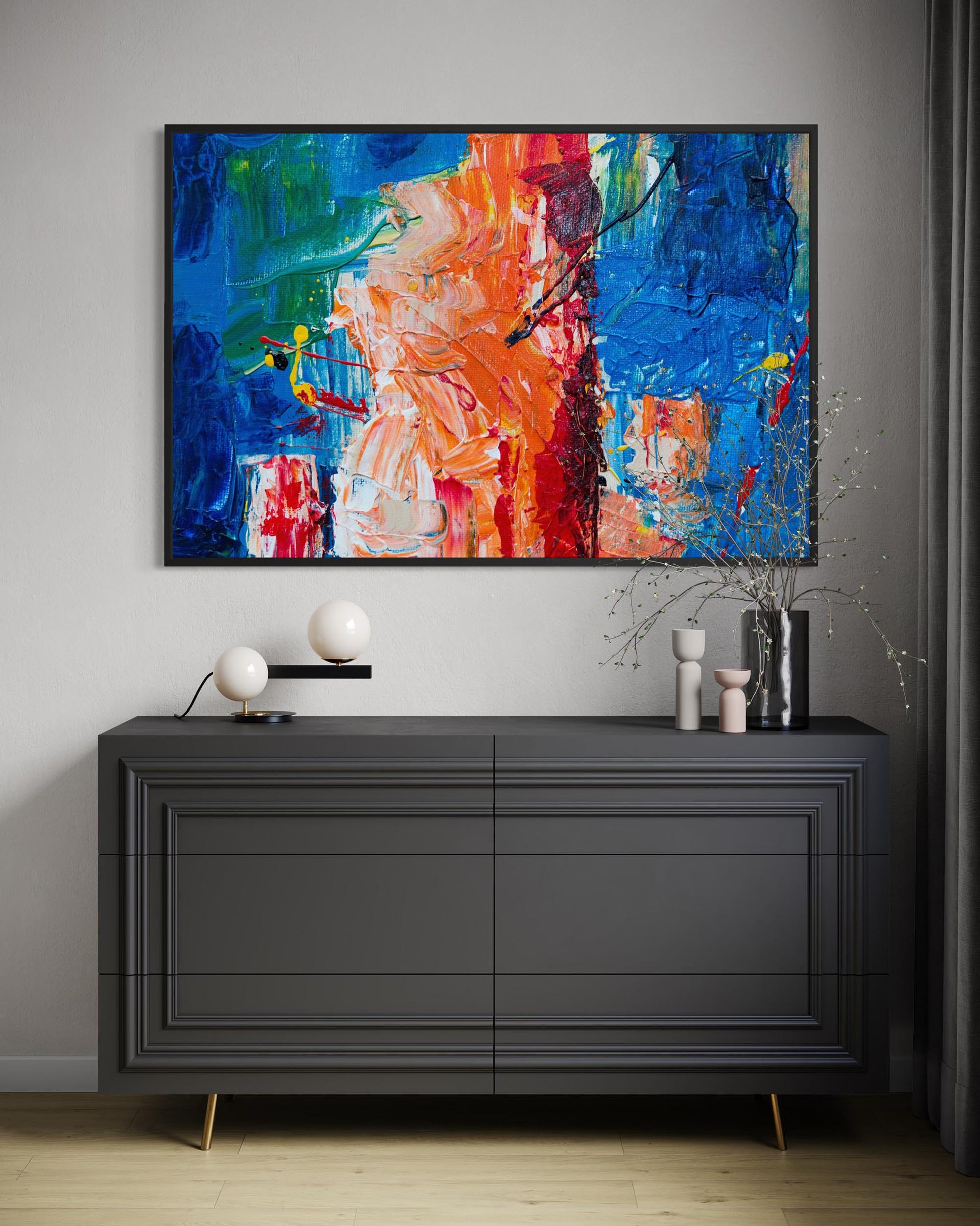 Modern interior with a black dresser and colorful abstract painting on a gray wall.