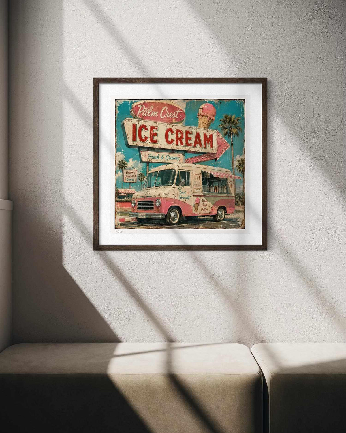 A framed vintage-style ice cream advertisement print hangs on a light gray wall above a beige sofa, with diagonal window shadows casting across the scene.