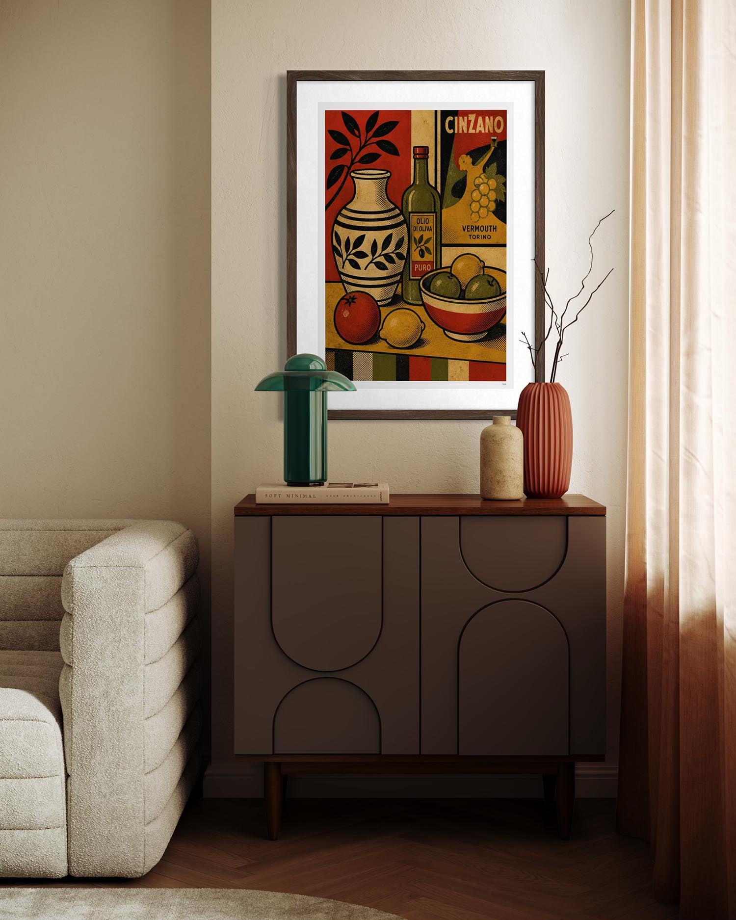 A framed vintage-style still life art print hangs on a beige wall above a dark wood sideboard in a styled living room. The artwork features a vase, fruit, and a bottle with the word 'CINZANO' visible.