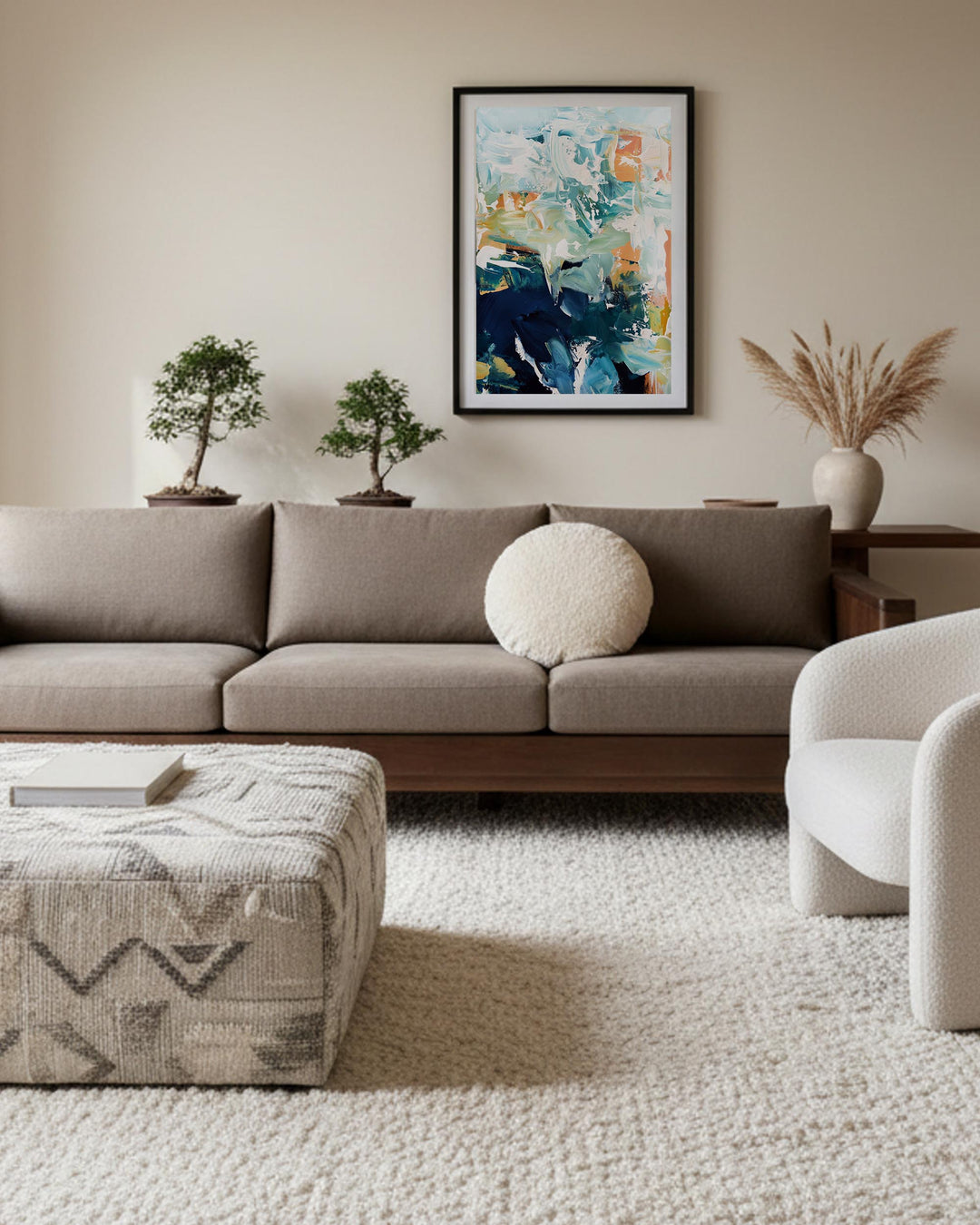 Modern living room with a beige sofa, abstract art, and decorative plants.