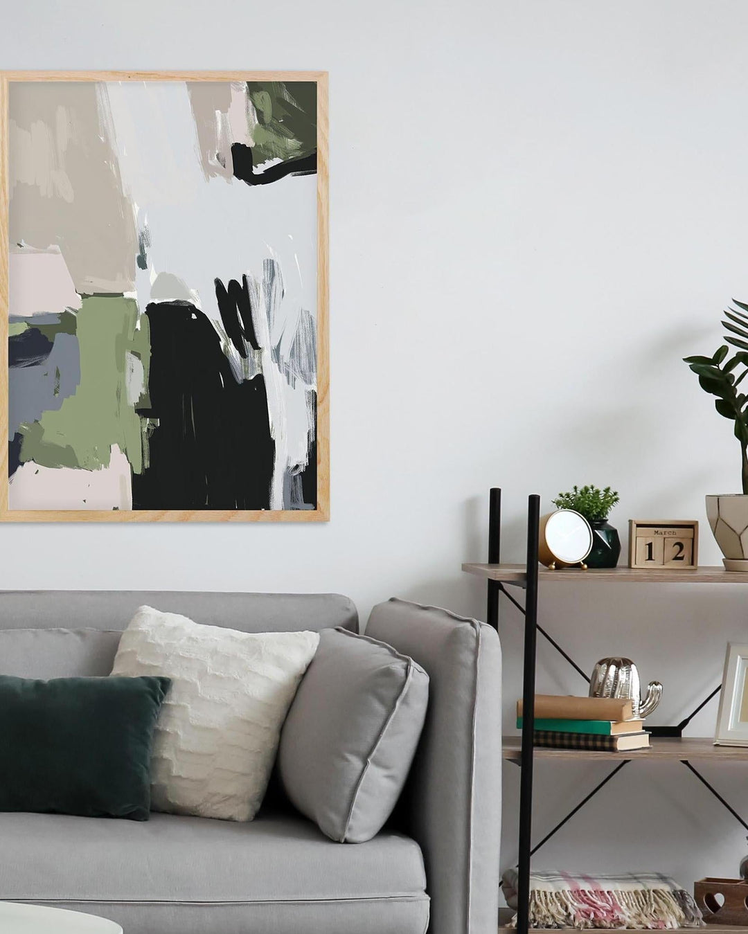 Living room with abstract art on the wall, gray sofa, and decorative items.