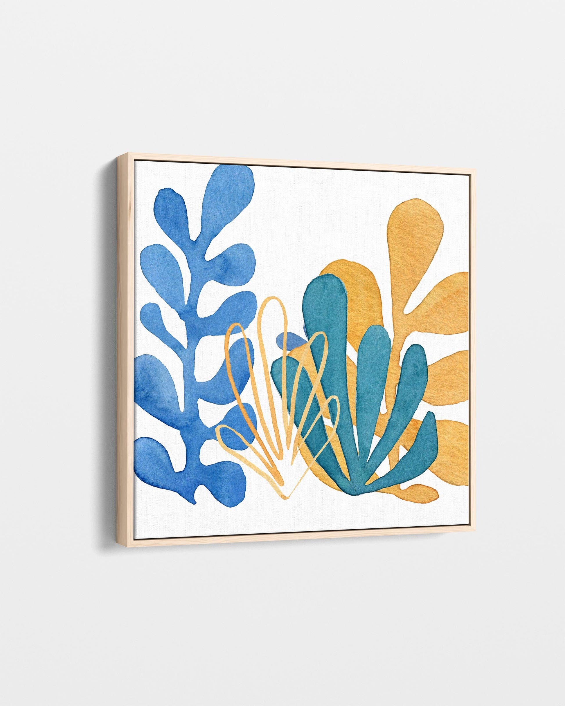 Framed artwork with blue and gold abstract leaf designs on a white background