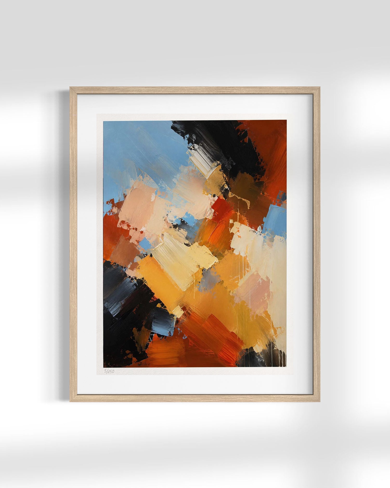 Framed abstract wall art featuring expressive brushstrokes in orange, blue, black, cream, and brown, displayed in a light wood frame with a white mat against a light gray wall.