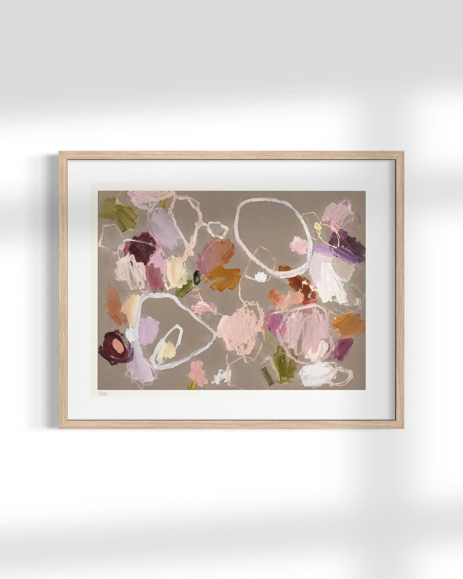 Framed abstract wall art hanging on a white wall, featuring a light wood frame, white mat, and an abstract painting with soft pink, purple, brown, and beige tones.