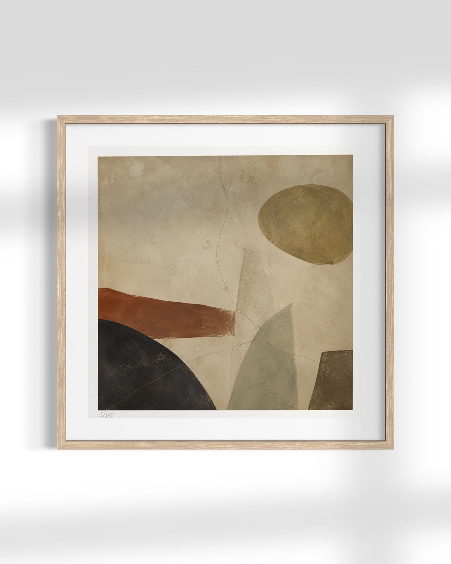 Framed abstract wall art with geometric shapes in beige, brown, black, and muted green tones, shown in a light wood frame against a white wall.