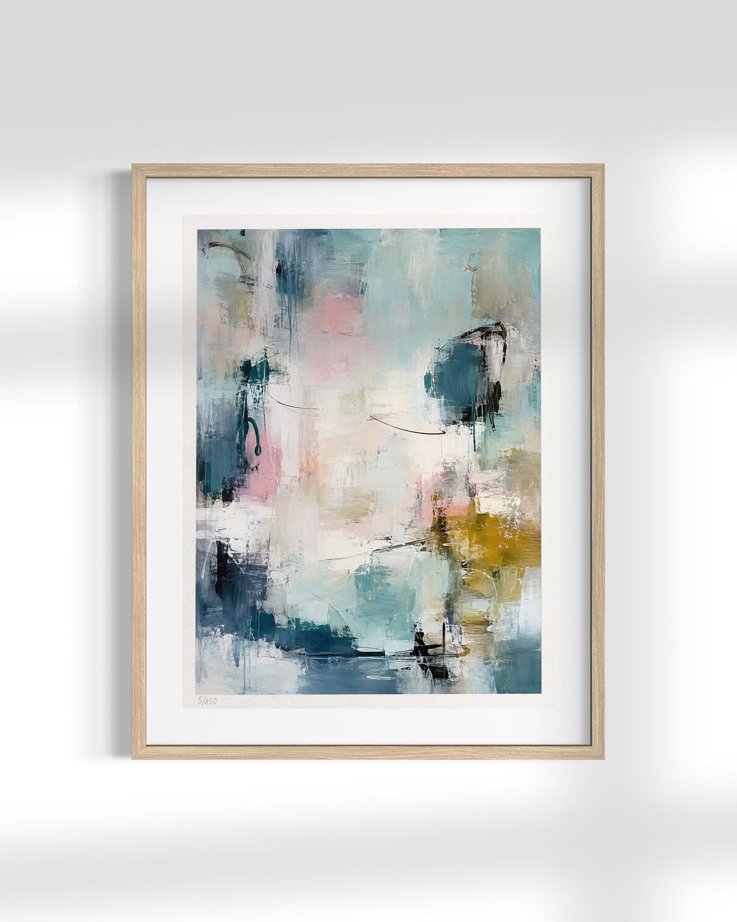 A framed abstract art print featuring a modern, painterly composition with blue, teal, pink, white, and gold brushstrokes, set in a light natural wood frame with a white mat against a white wall.