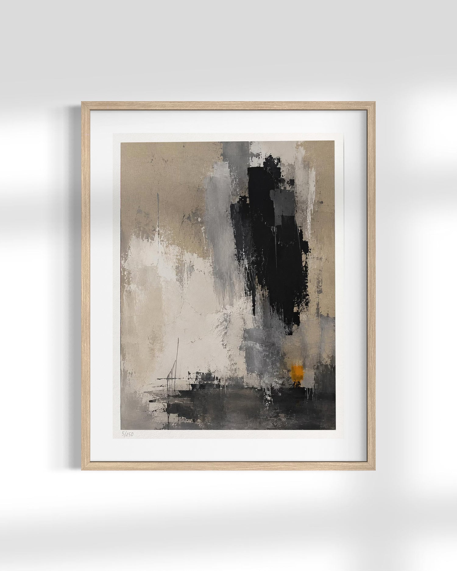 Framed abstract wall art featuring a modern composition of black, gray, beige, and white brushstrokes with a small warm orange accent, presented in a light wood frame against a white wall.