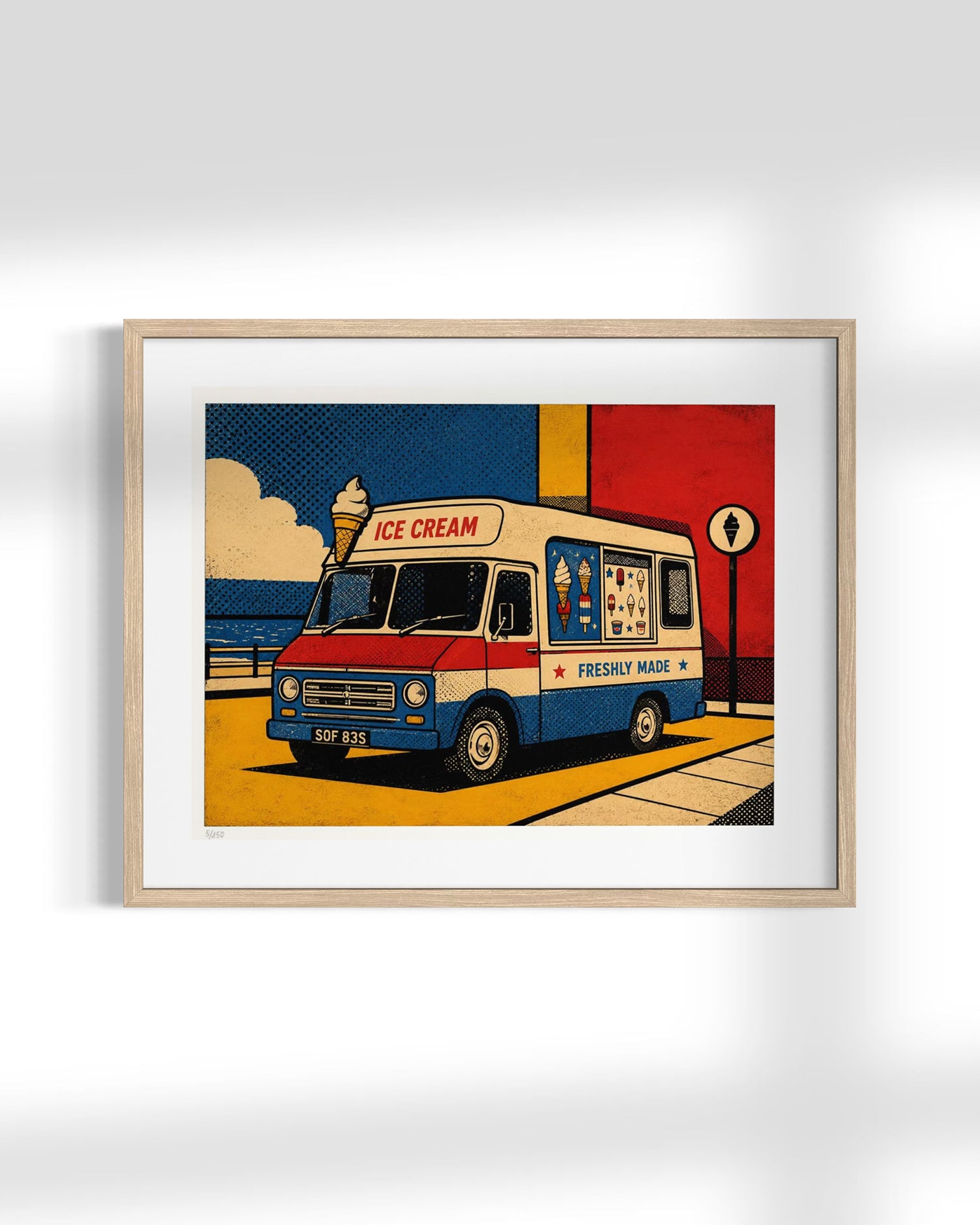 A framed pop-art style print of a retro ice cream truck, shown hanging on a light gray wall. The artwork features a cream, red, and blue truck with bold graphic elements, and the frame is mounted with a white mat.