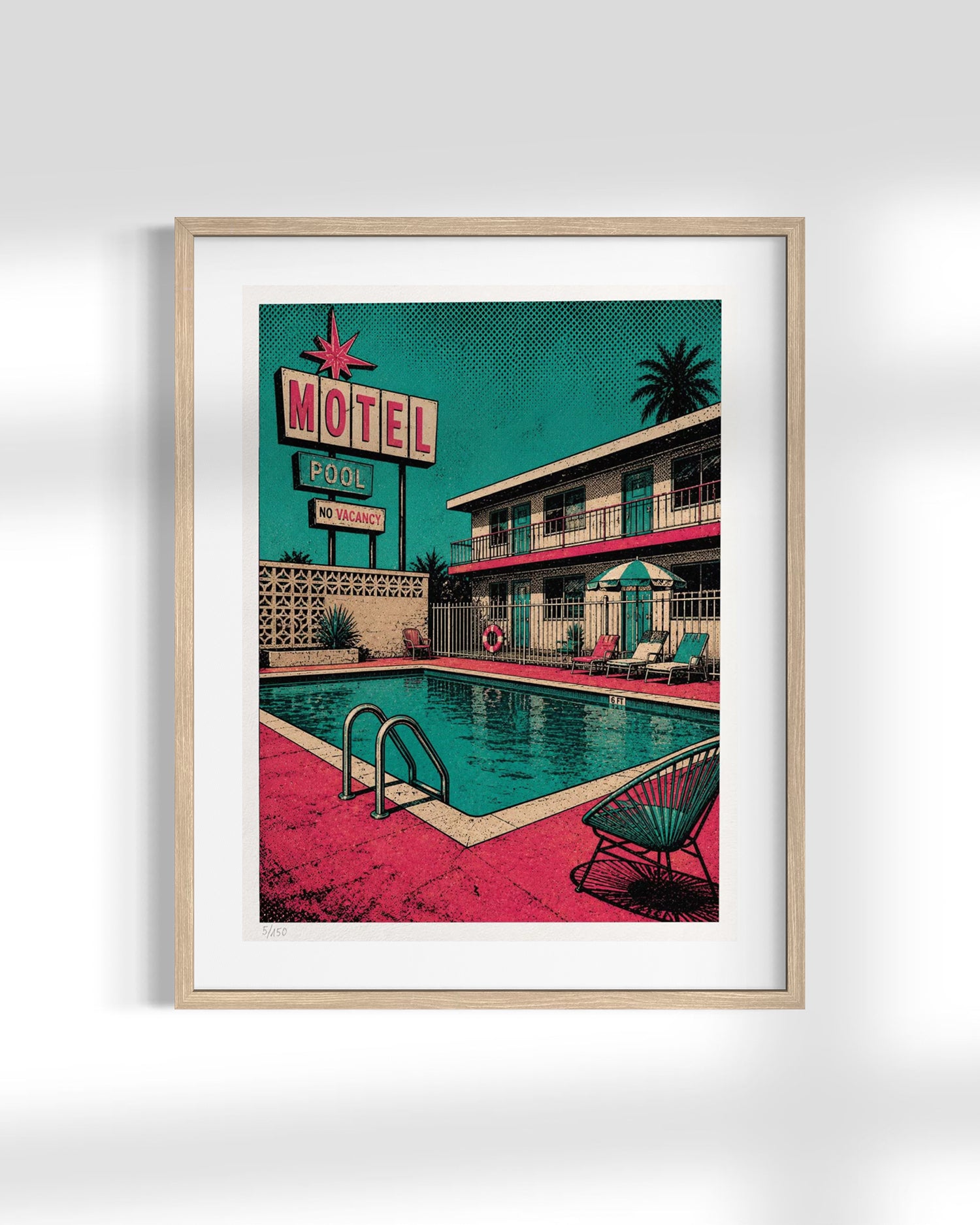 A framed art print featuring a retro 1950s motel pool scene with a teal sky, pink poolside, and a two-story motel building, displayed on a light gray wall.