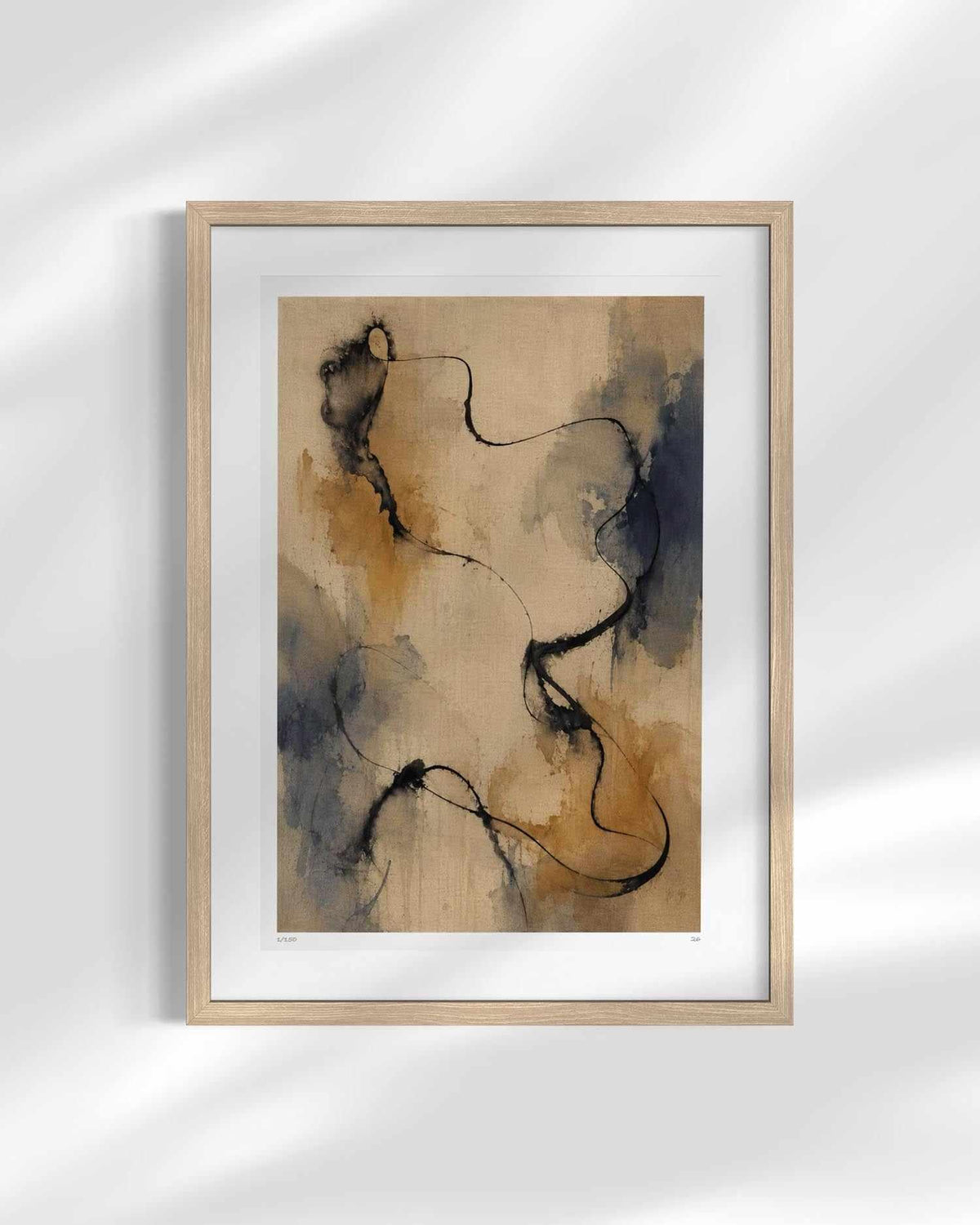 Framed abstract wall art print with flowing black line work over a warm beige and brown watercolor background, shown in a light wood frame with a white mat against a softly lit wall.