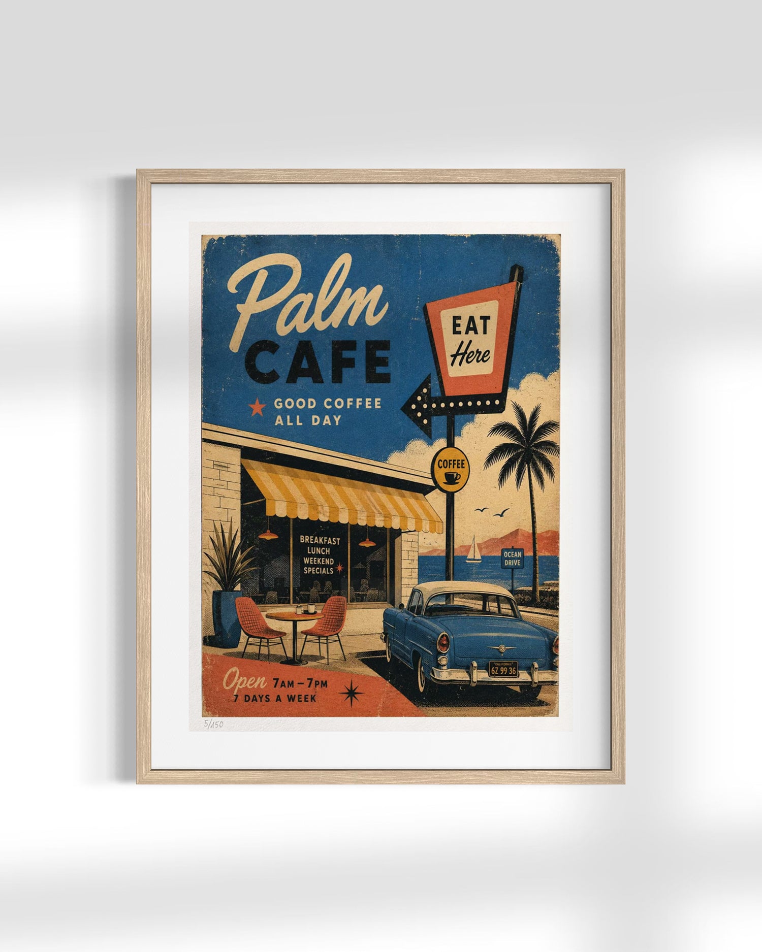 A framed vintage-style cafe poster reading 'Palm Cafe' with retro signage, palm trees, a blue car, and a beach scene, displayed against a light gray wall.