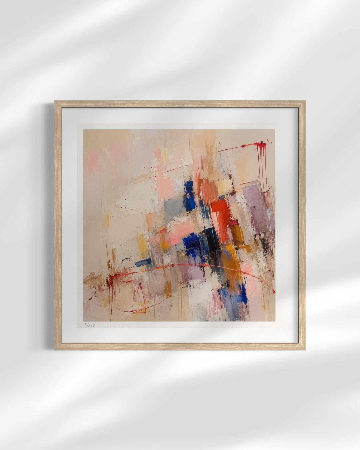 Framed abstract wall art hanging on a white wall, featuring a light wood frame, white mat, and an abstract painting with beige, pink, blue, red, and orange brushstrokes.