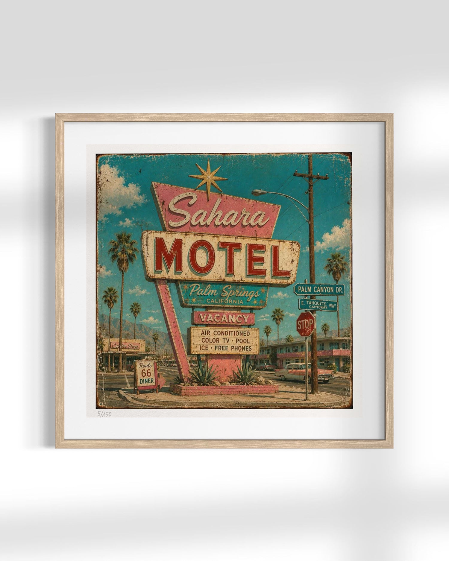 Framed wall art featuring a vintage-style illustration of the Sahara Motel at Palm Springs, with a light wood frame and white mat on a light gray background.