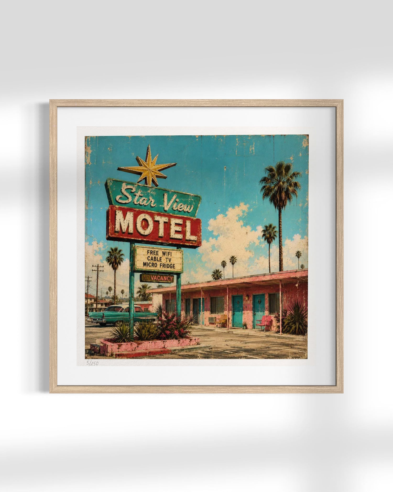 Framed wall art featuring a retro 1950s motel sign and motel building scene, shown in a light wood frame against a white wall.