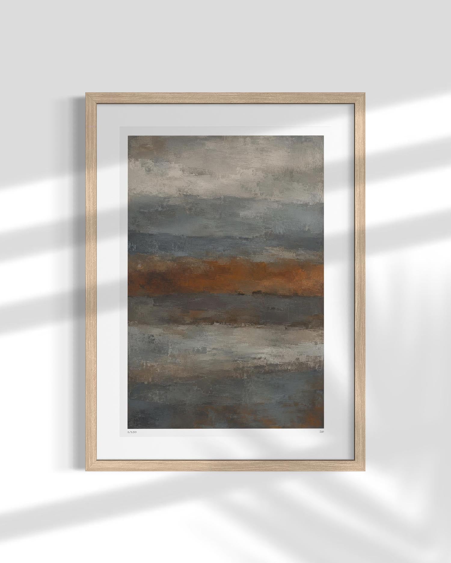 Framed abstract landscape art print with horizontal bands of gray, brown, and muted blue, displayed in a light wood frame against a white wall with soft shadow overlays.