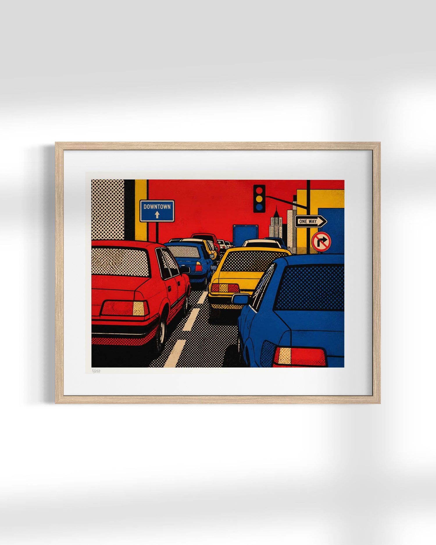 A framed pop art print depicting a busy city street with red, yellow, and blue cars, mounted on a light gray wall.