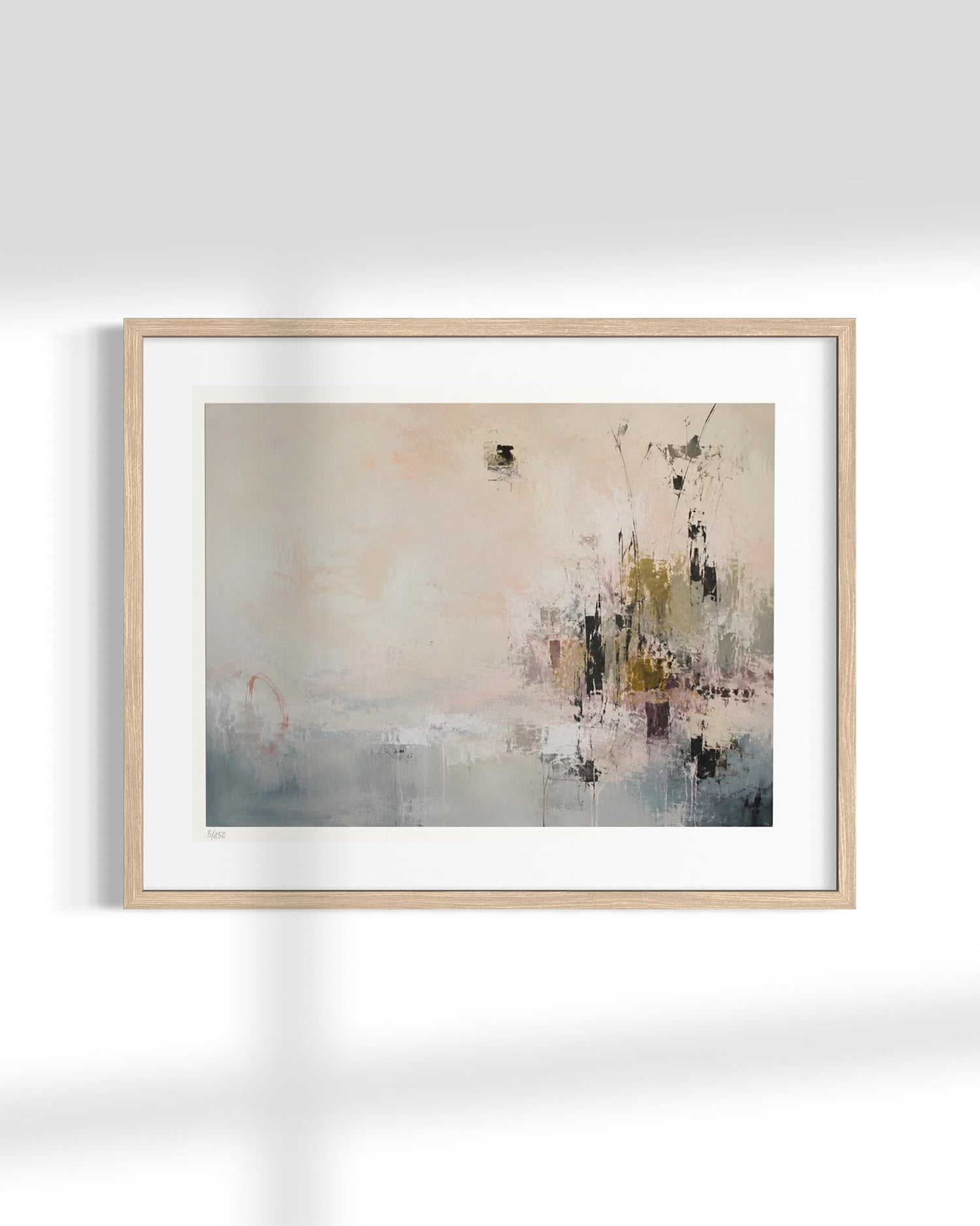 A framed abstract art print with a light wood frame and white mat, featuring soft beige, gray, and muted blue-green brushstrokes, displayed against a white wall with soft shadows.
