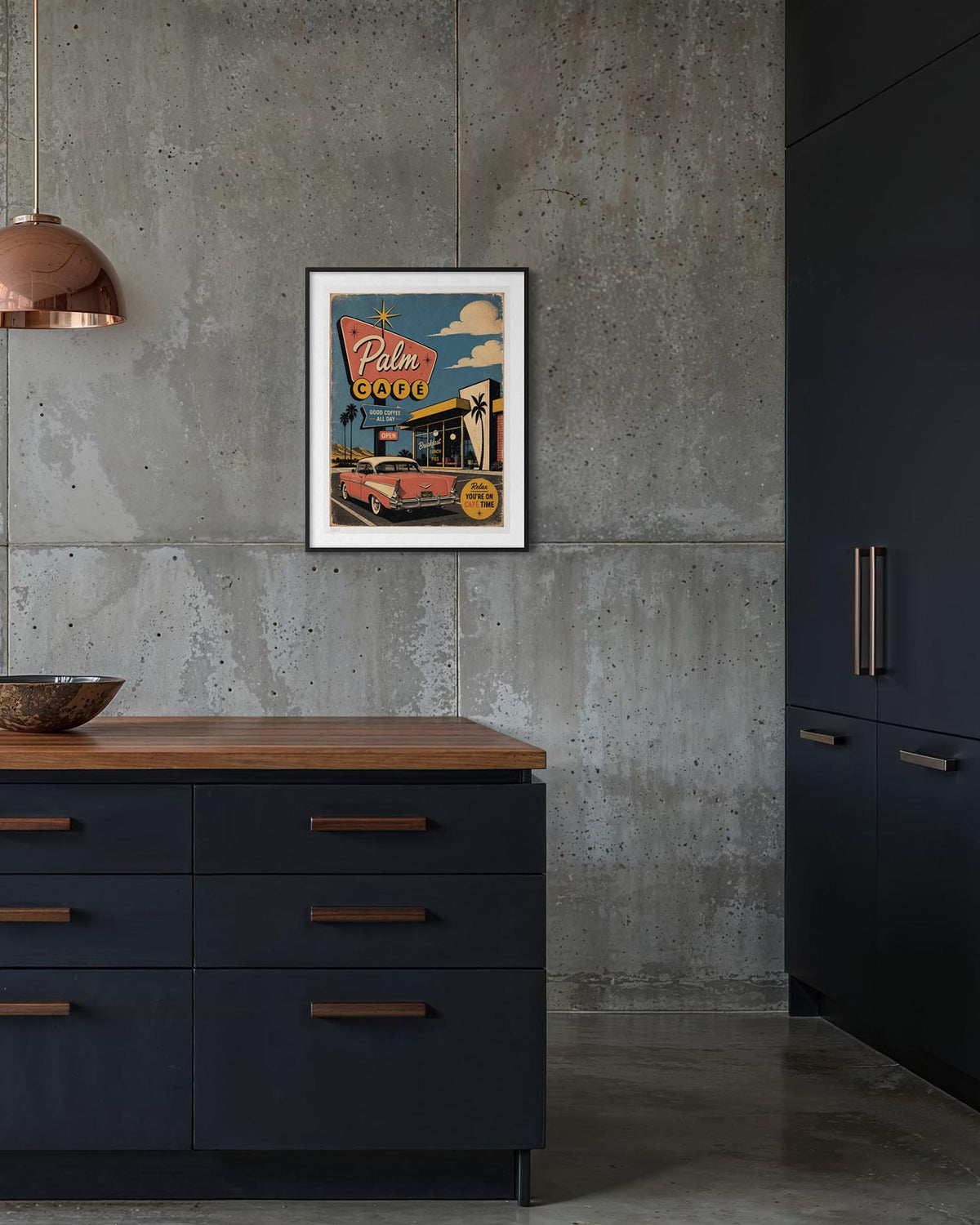 A framed vintage-style travel poster reading 'Palm Beach' hangs on a concrete kitchen wall above a dark cabinet with a wood countertop.