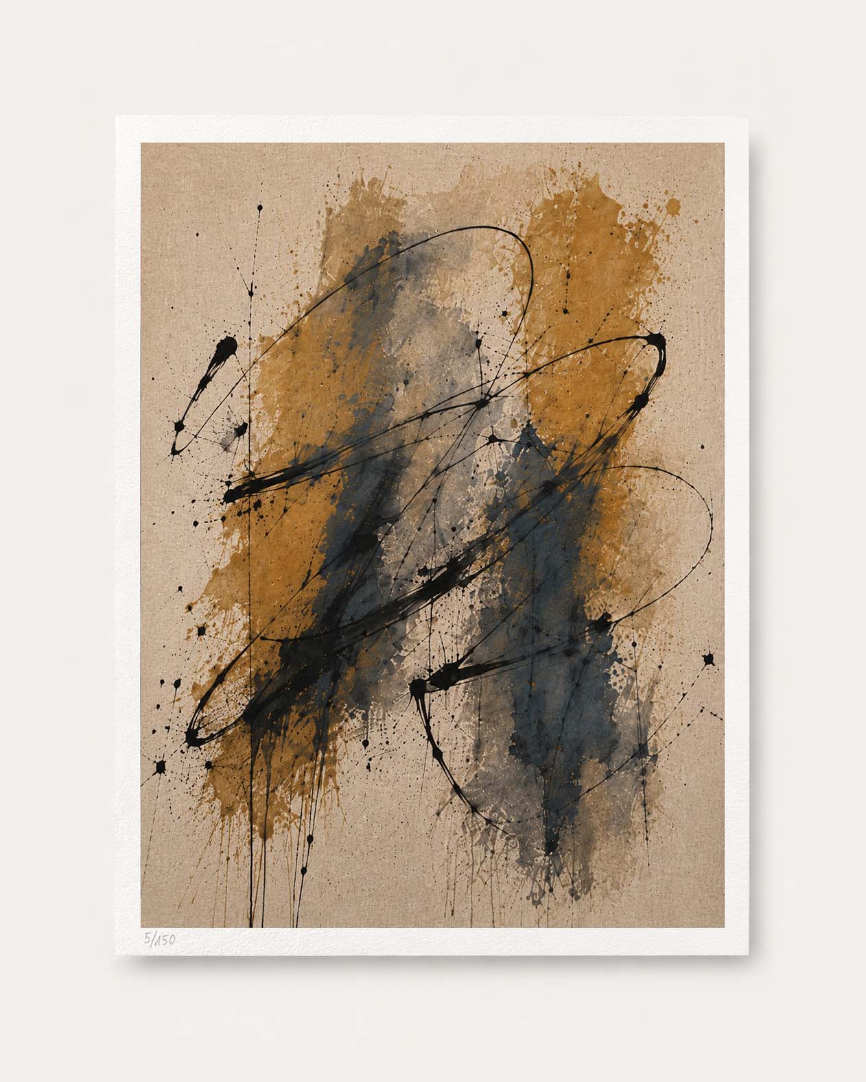 An abstract art print featuring expressive black paint splatters and brushstrokes over a textured beige background with warm ochre and gray washes, presented with a white border on a light neutral wall.