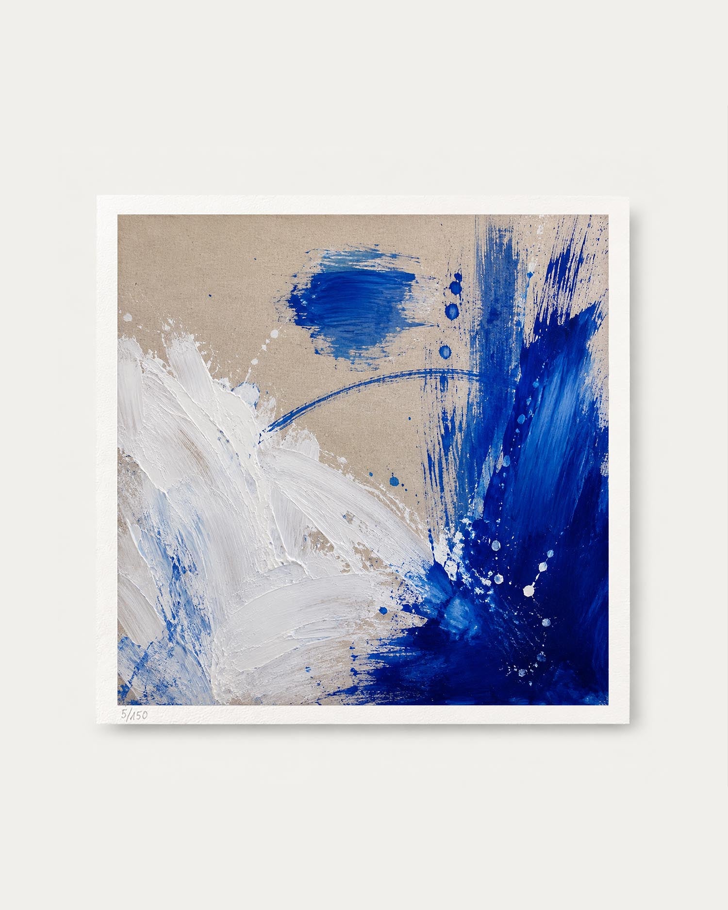 An abstract square art print featuring textured blue and white paint strokes on a warm beige background, presented with a white border against a light gray wall.
