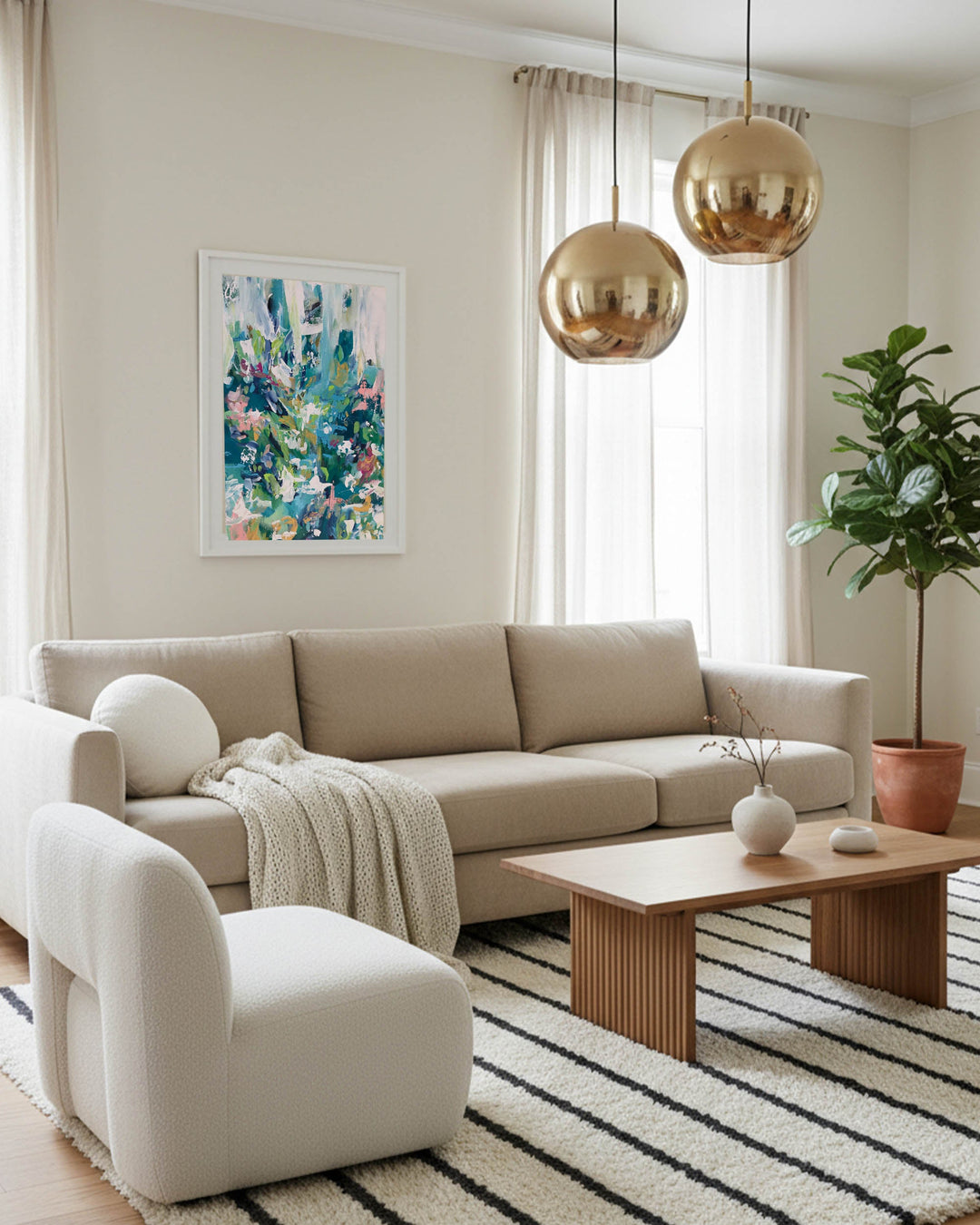 large wall art framed with modern colourful palette, brass bubble light and 3 seater beige fabric sofa and large olive tree.