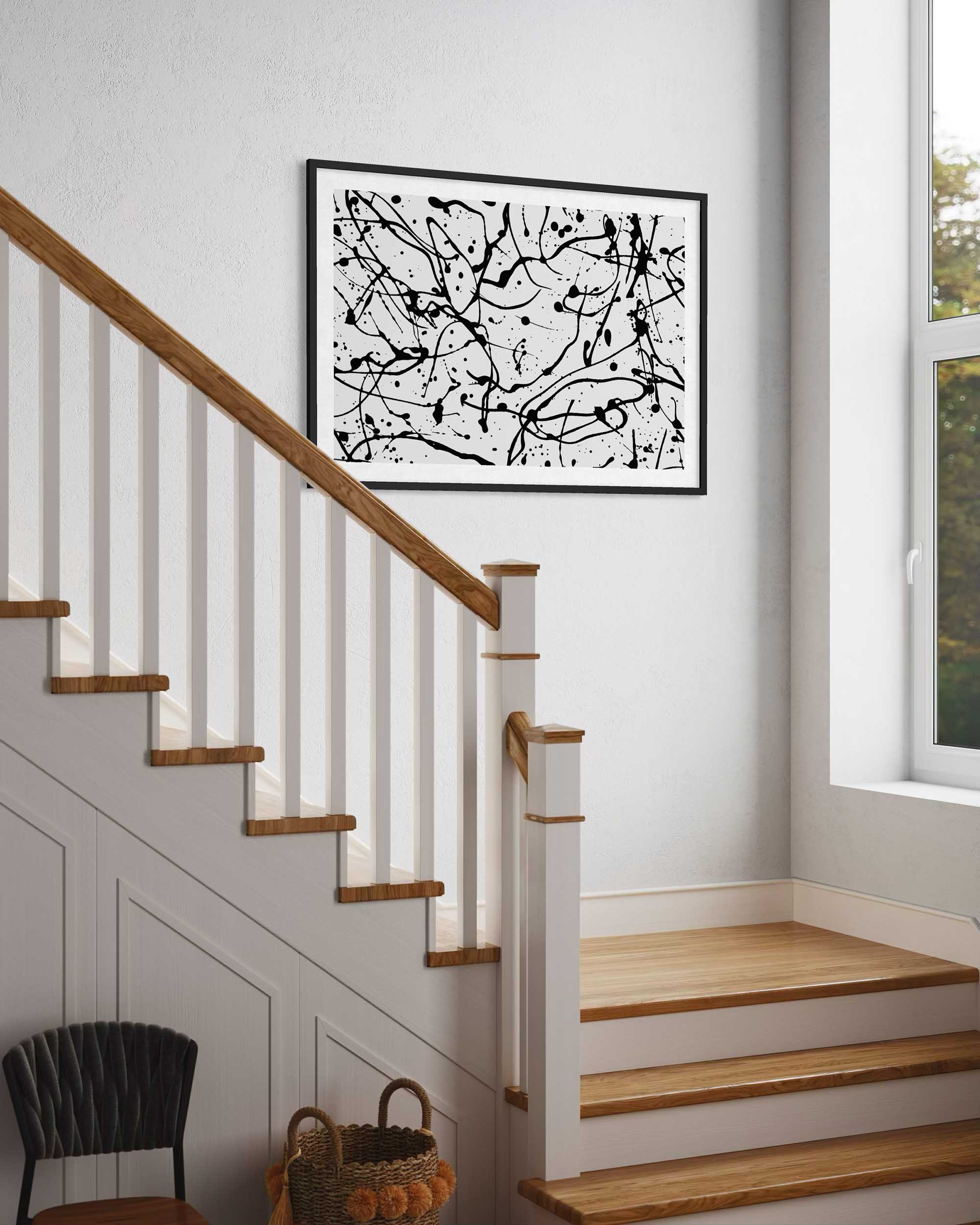 Abstract black and white artwork on a wall above a staircase