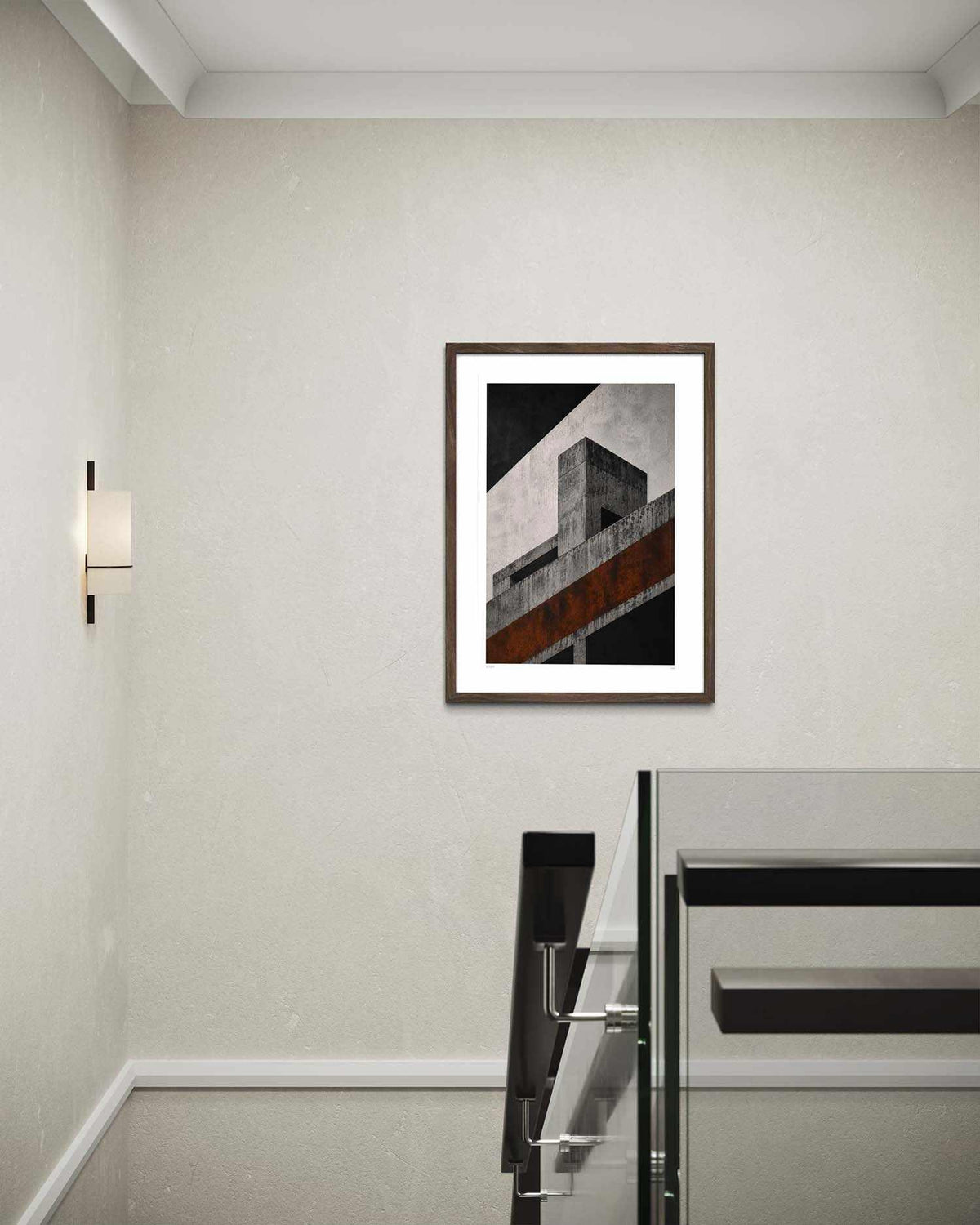 A framed abstract architectural art print featuring a geometric building design in black, gray, and rust-orange tones, displayed on a textured beige wall in a modern interior setting.