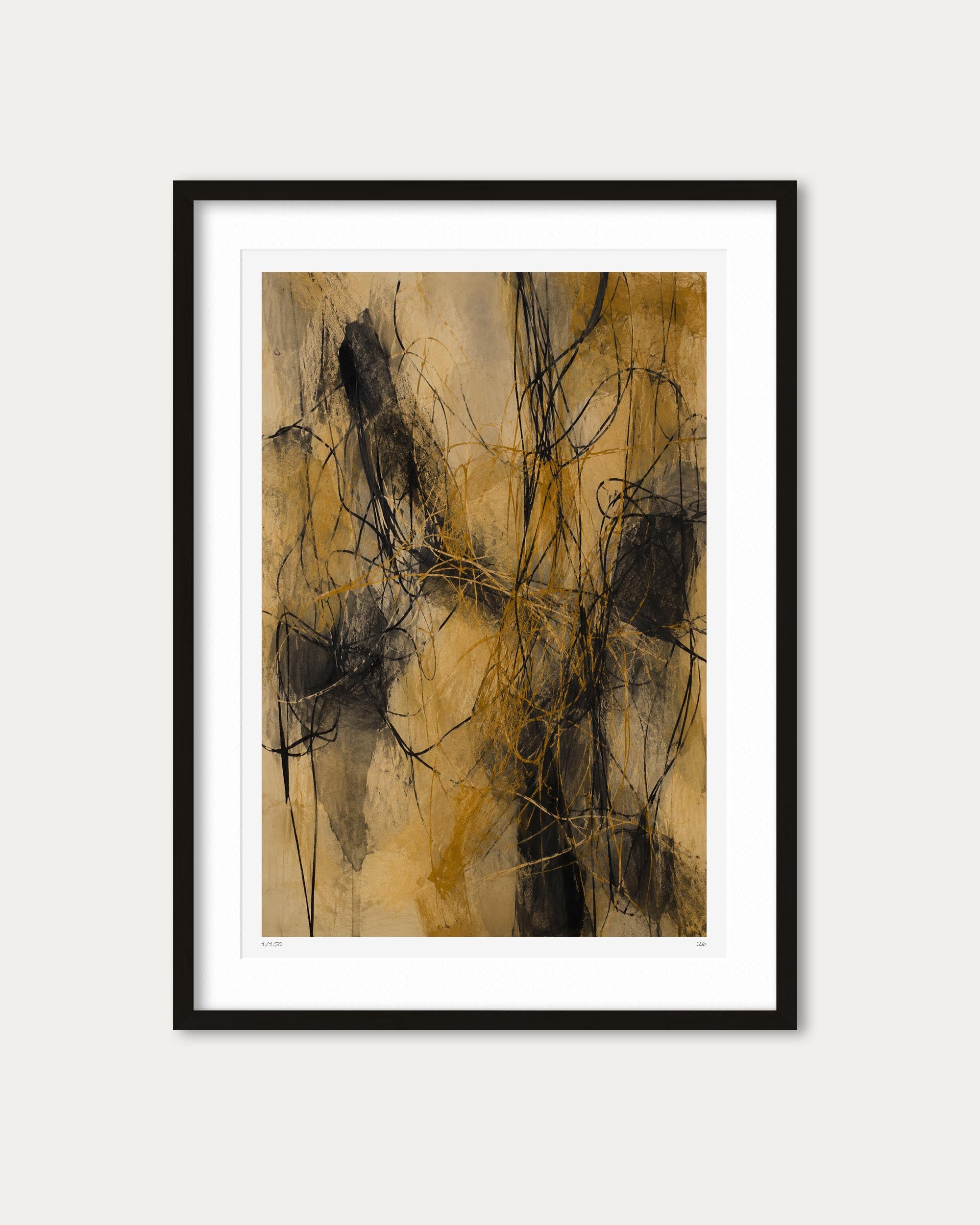 A framed abstract art print featuring expressive black and gold brushstrokes on a textured beige background, presented in a black frame with a white mat against a light gray wall.