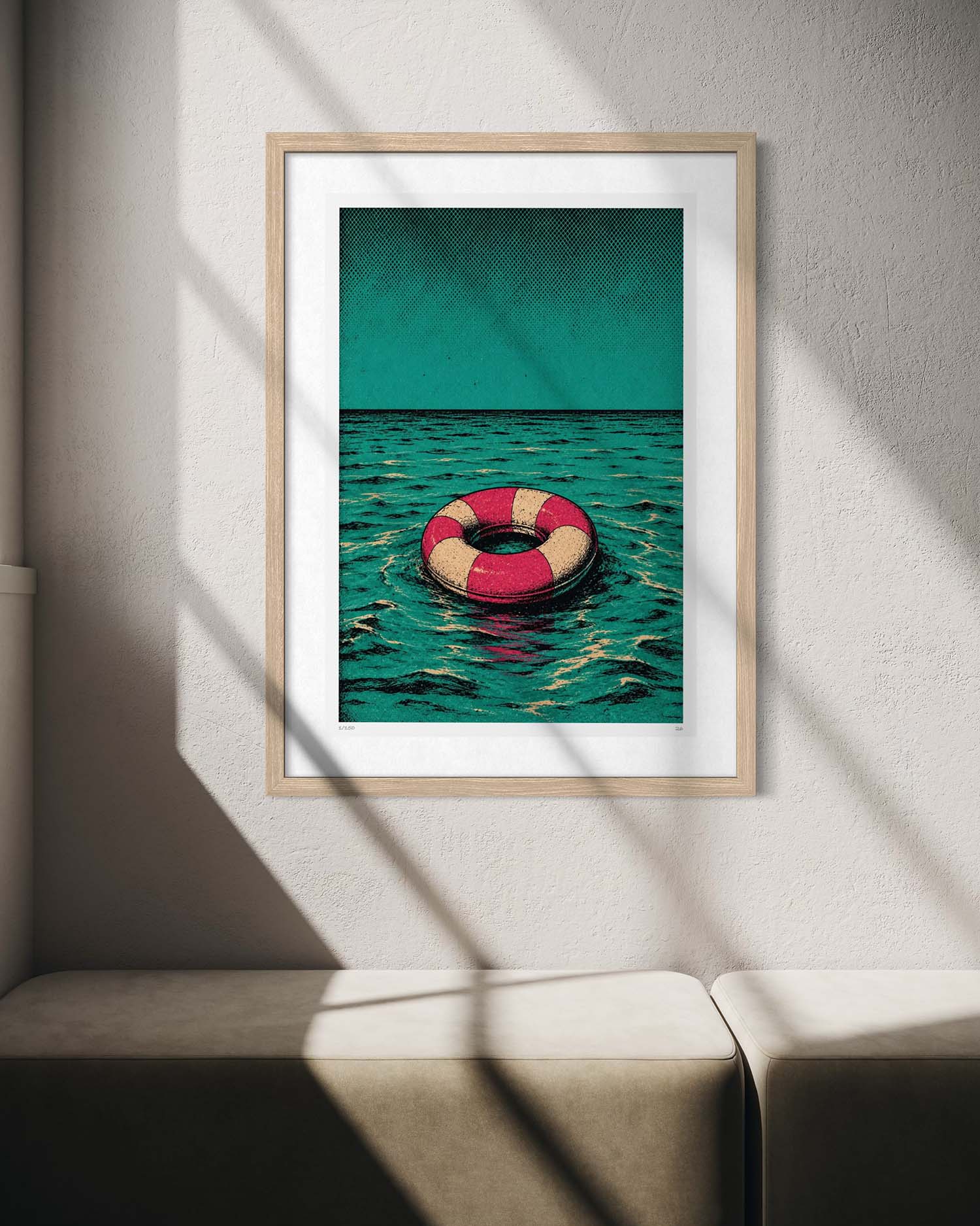 A framed art print featuring a red and cream life preserver floating on teal water under a teal sky, displayed on a textured light gray wall with diagonal window shadows.