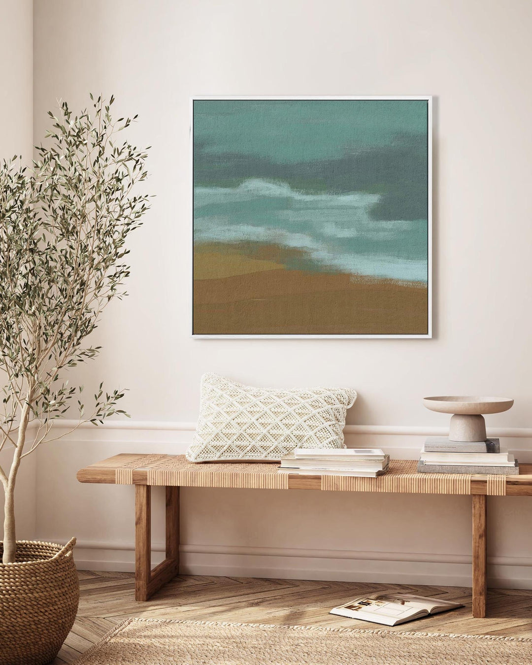 Framed abstract artwork on a wall above a wooden bench with decorative items.