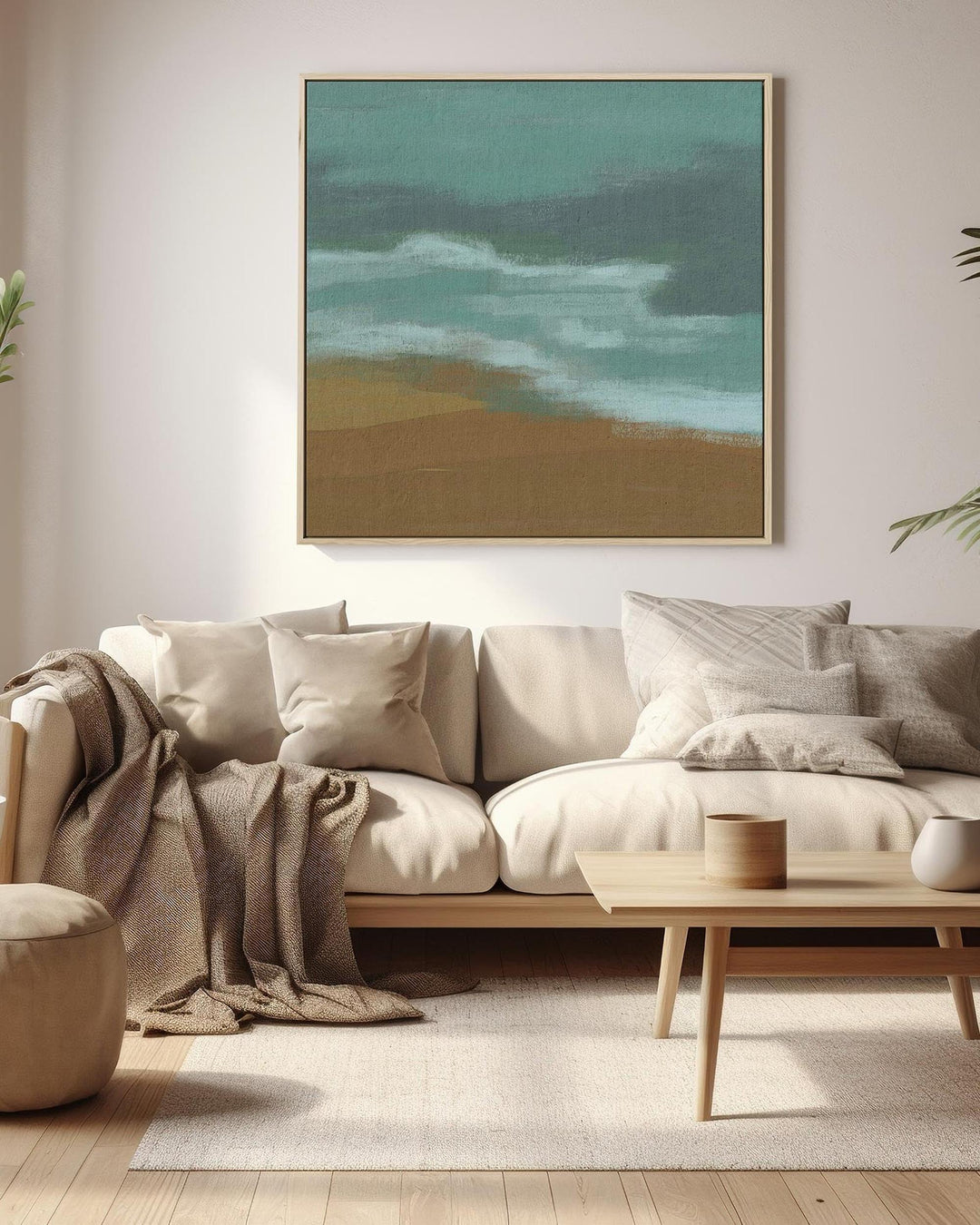 Modern living room with a beige sofa, wooden coffee table, and a painting of a beach scene on the wall.