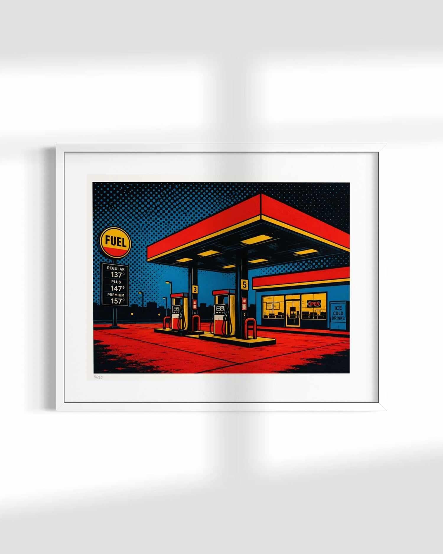 A framed pop art print depicting a stylized gas station with bold red, yellow, blue, and black colors, shown hanging on a white wall.