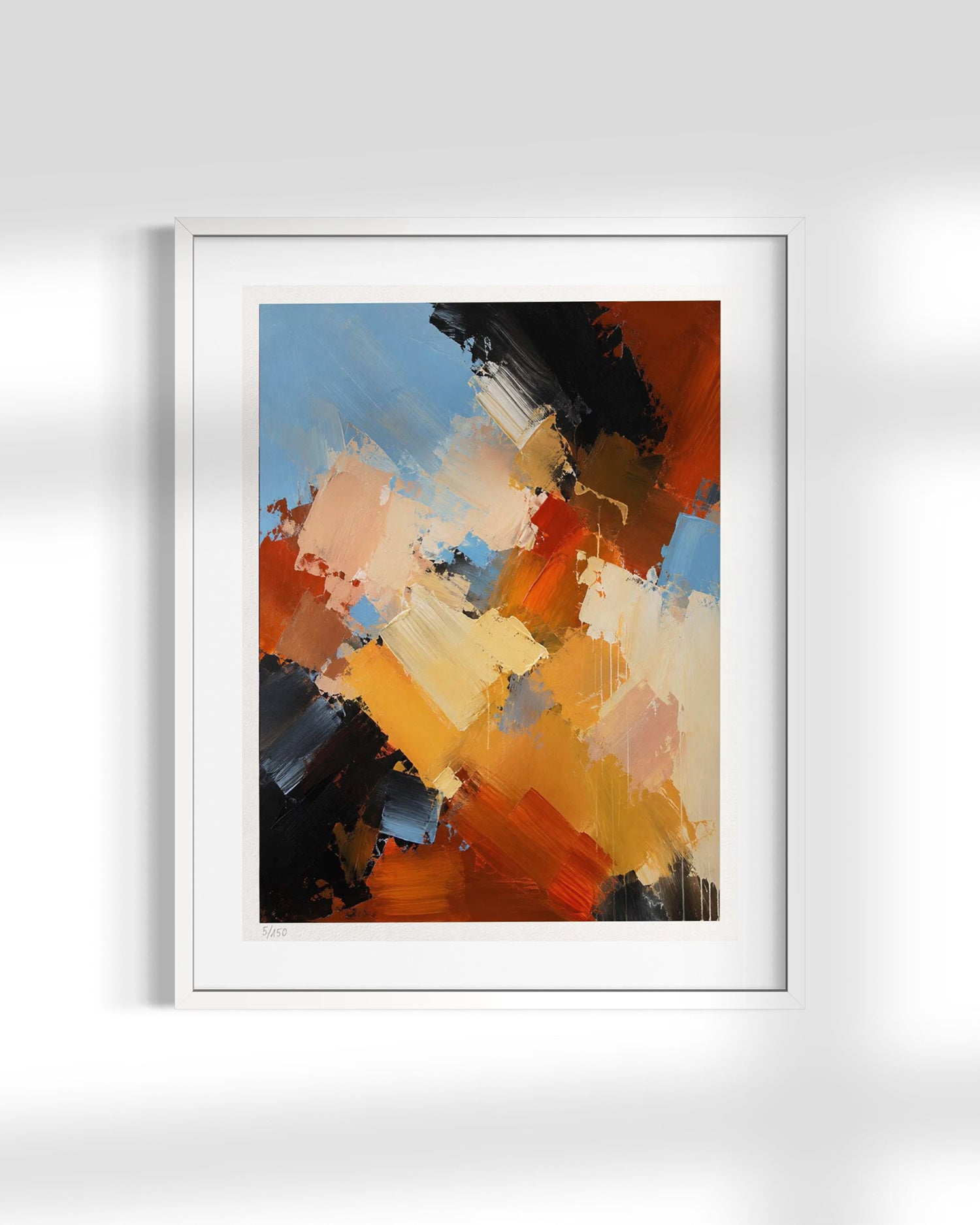 A framed abstract canvas print featuring expressive brushstrokes in orange, yellow, blue, black, and beige, displayed on a light gray wall with soft shadows.