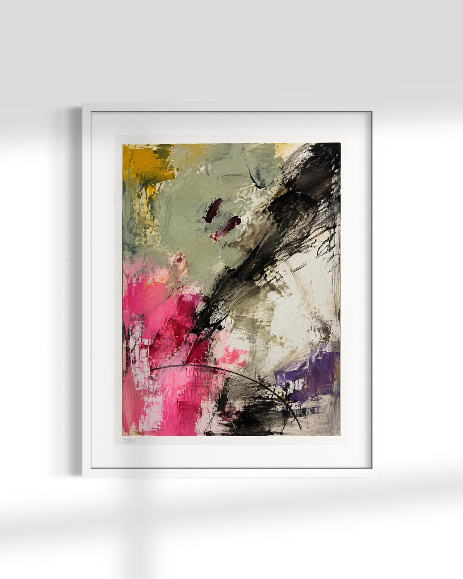 A framed abstract art print featuring expressive brushstrokes in black, pink, purple, yellow, and gray on a white mat and frame, displayed against a light gray wall.