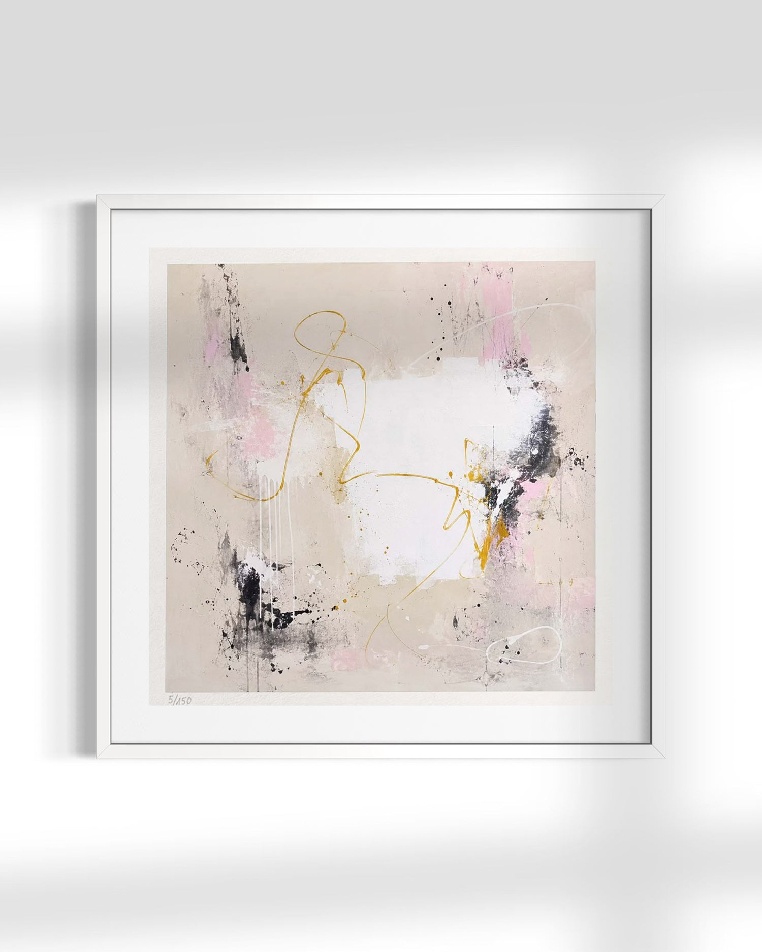 A framed abstract art print featuring a minimalist composition with a white background, soft pink and black brushstrokes, and delicate gold line details, presented in a white frame against a light gray wall.
