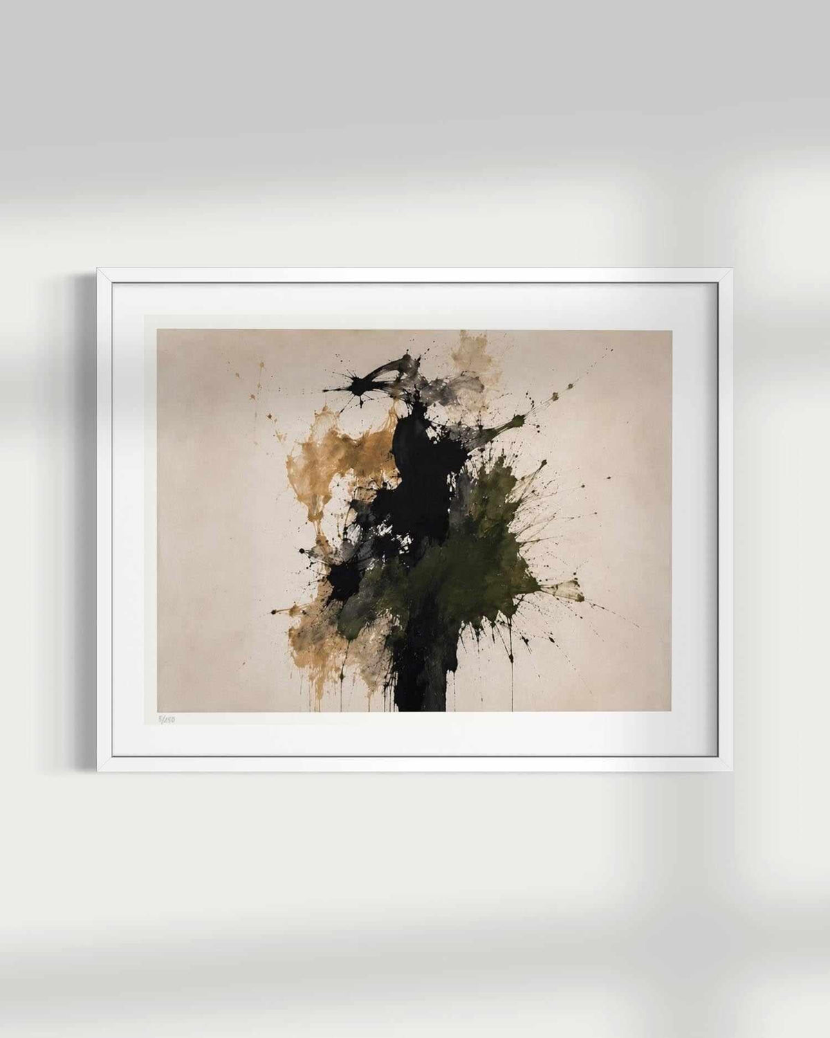 A framed abstract art print featuring a textured beige background with expressive black, olive green, and ochre paint splatters, presented in a white frame against a light gray wall.