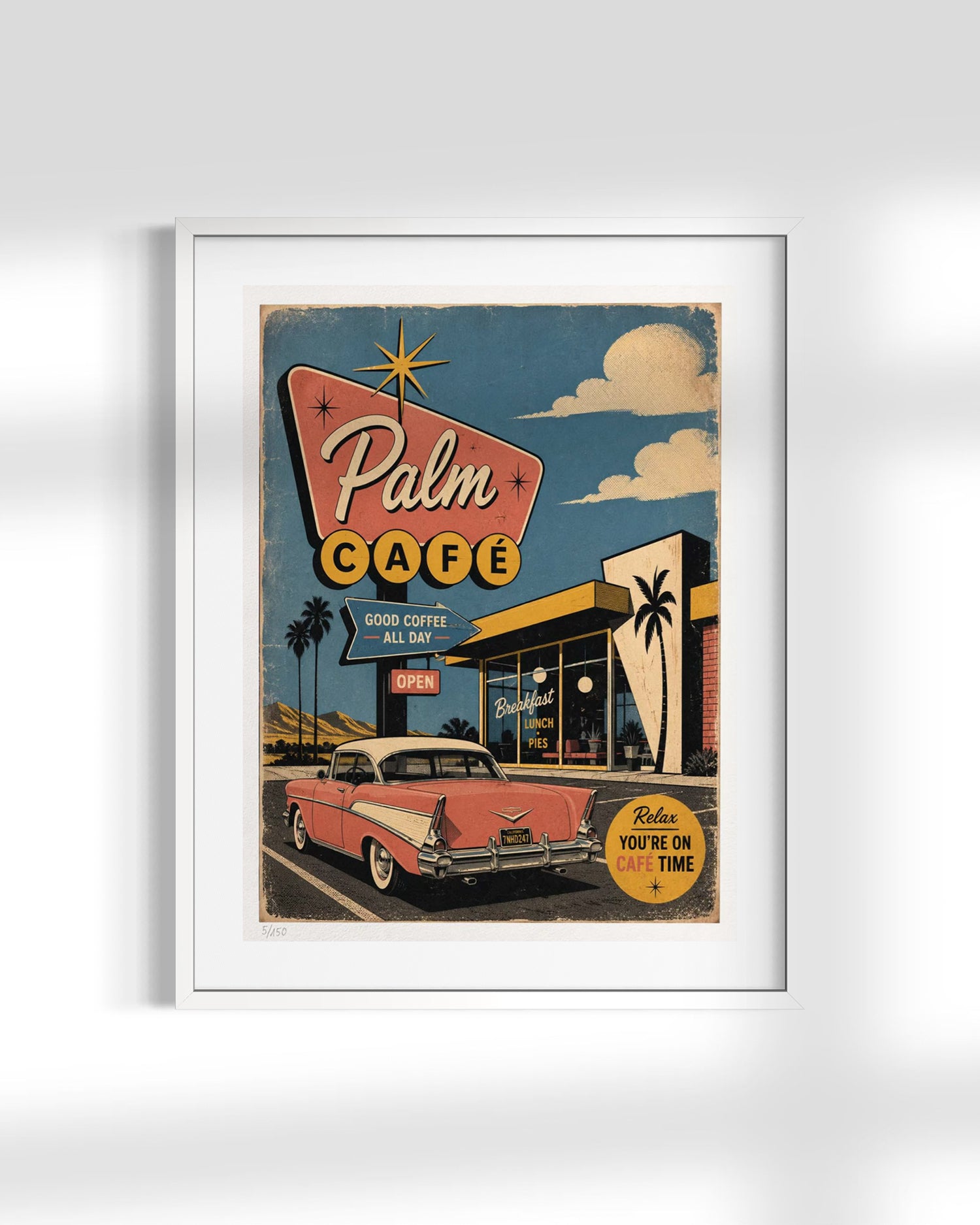 A framed retro-style poster featuring a vintage Palm Cafe sign, storefront, palm trees, a pink classic car, and a blue sky with clouds, shown against a light gray wall.