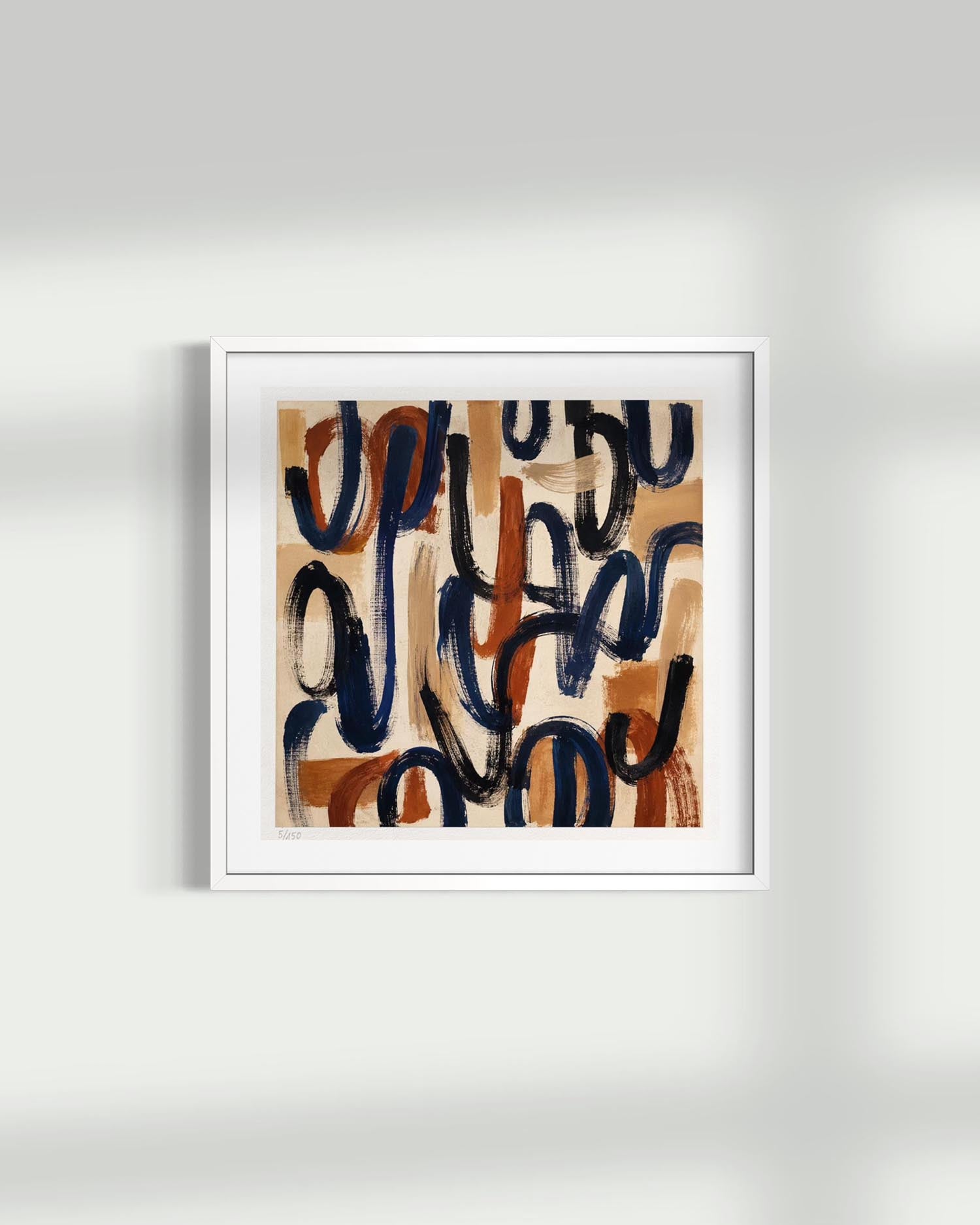 A framed abstract art print featuring expressive black and terracotta brushstrokes on a warm beige background, housed in a clean white frame and mounted on a light gray wall.