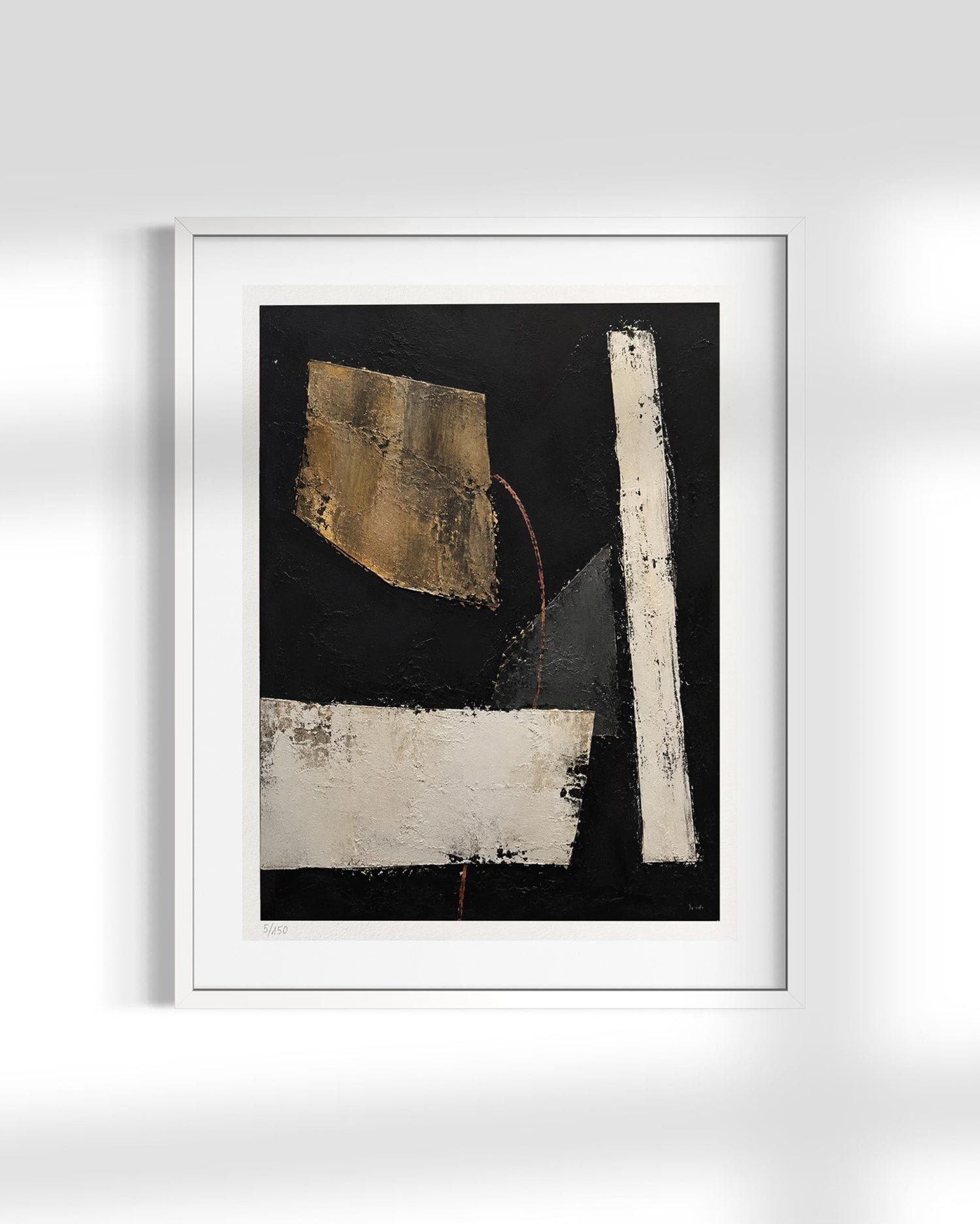A framed abstract art print featuring a black background with textured white and gold geometric shapes, presented in a white frame against a light gray wall.