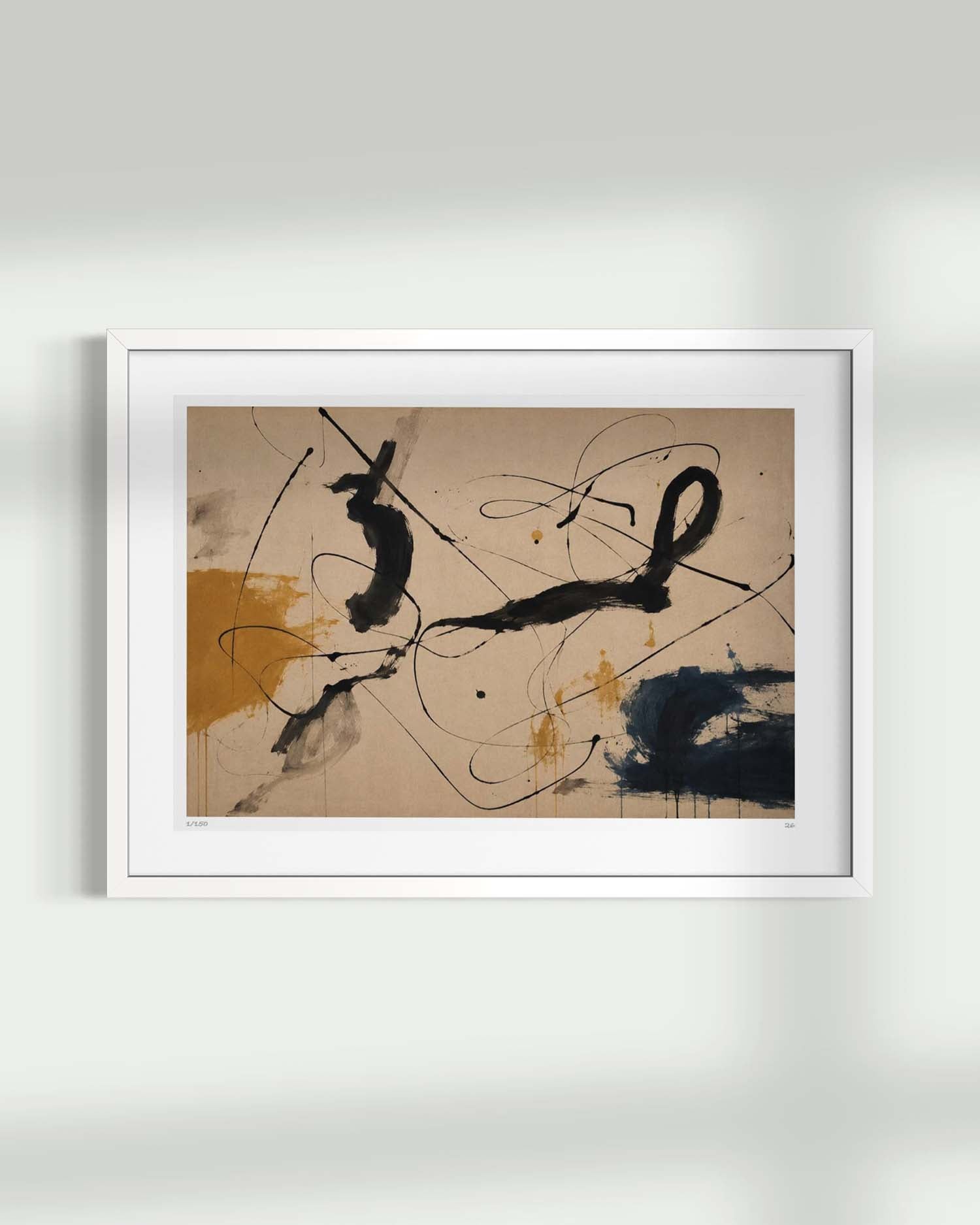 A framed abstract art print featuring black brushstrokes and splatters on a beige background with mustard and navy accents, displayed on a light gray wall.