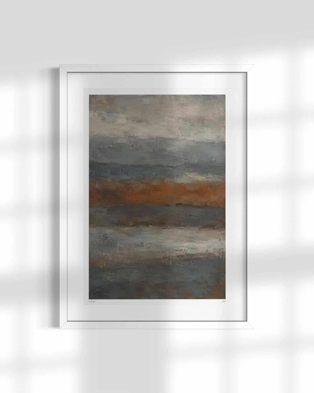 A framed abstract landscape art print featuring horizontal bands of gray, brown, and blue, displayed in a white frame against a light gray wall with soft window shadow overlays.